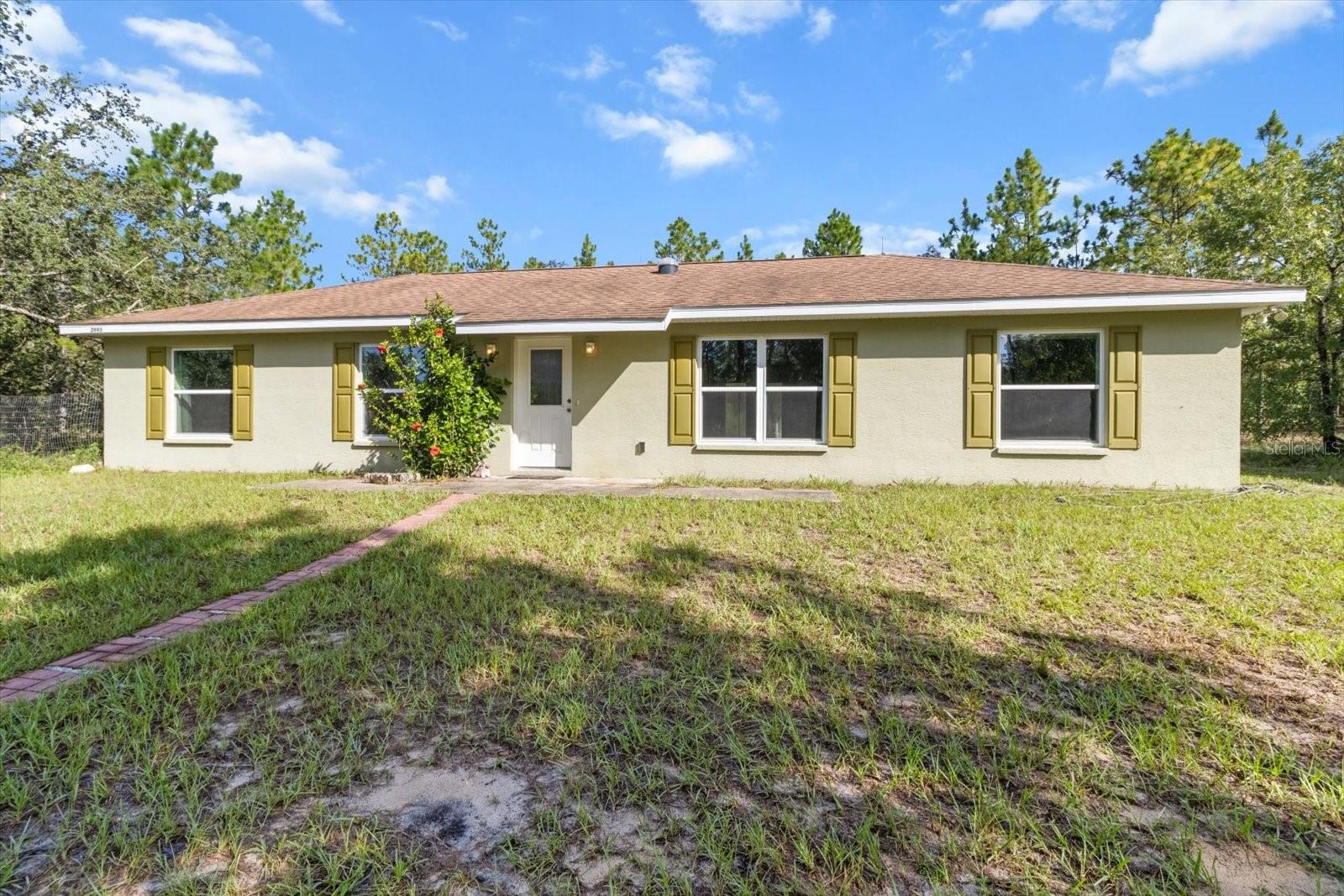 Escape to privacy and space with this 2017-built 3 bedroom, 2 bathroom home situated on over 10 acres of serene, wooded land. Nestled well off the road and not visible from the street, this property offers seclusion without sacrificing convenience. Inside, the 1,392 sq ft layout features a functional galley kitchen equipped with a refrigerator, dishwasher, microwave, and electric range. The primary suite includes an en-suite bath, while the two spacious guest bedrooms provide comfort and flexibility. An oversized shed on the property offers endless possibilities for a workshop, storage, or hobby space. The circular unpaved driveway adds to the rustic charm and provides ample parking. Enjoy the best of both worlds—peaceful living and central access to shopping, dining, and recreation. You’re just minutes from golf courses, fishing, boating, and manatee sightseeing, with the Suncoast Parkway nearby for easy commutes to Tampa and Clearwater. Plus, the new Target is just 10 minutes away!