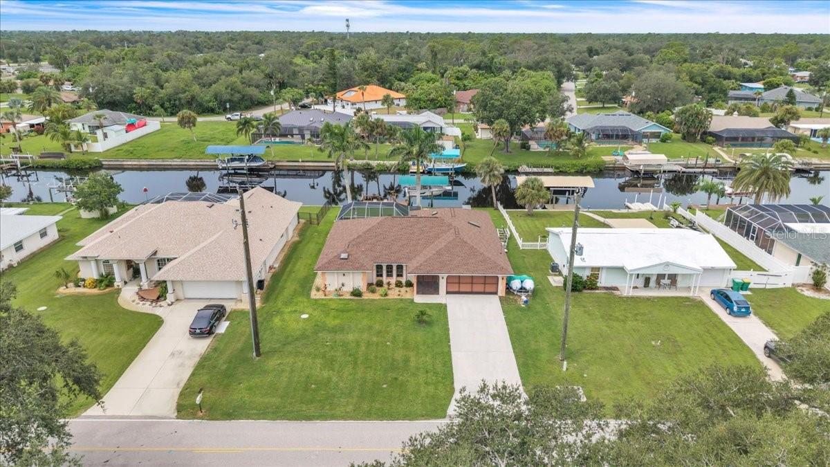 Don’t miss this exceptional opportunity to own a beautiful 3-bedroom, 2-bath waterfront pool home with attached garage, perfectly located in the heart of Port Charlotte. With 80 feet on the Pellam Waterway, this property offers a short boat ride to Charlotte Harbor and the Gulf of Mexico—an absolute boater’s dream. Featuring 2,239 sq. ft. of thoughtfully designed living space, the home blends comfort and functionality throughout. Step through the foyer into a bright and open living area with tile flooring and new wood laminate. Sliding glass doors lead to the expansive Florida Room, creating a seamless flow for indoor-outdoor living. A dedicated dining area sits just off the living room, while the spacious kitchen offers Corian countertops with matching backsplash, modern appliances, breakfast bar seating, a serving window to the Florida Room, an abundance of cabinet and drawer storage—all overlooking the family room with cathedral ceilings and skylight. The private primary suite is a peaceful retreat with direct pool access, plush carpet, dual walk-in closets, and an en-suite bath featuring dual vanities, large mirrors, a walk-in shower, and private water closet. Two additional bedrooms, each with walk-in closets, share a full bath. The 30x12 air-conditioned Florida Room, lined with sliders, opens to your backyard oasis. Enjoy the heated, screened-in pool with a relaxing bench and built-in jets, along with the spacious deck, or take advantage of the boater’s amenities: covered boat lift, dock with electric and water and a tiled patio overlooking the waterway. Notable upgrades include: extended laundry room with washer/dryer, new A/C (2024), new pool chlorinator (2024), shingle roof (2022), four new skylights, whole house re-plumbed overhead (2020), Low Pressure Sewer County maintained (2021), well for irrigation, fresh exterior paint, updated light fixtures, and Boat Lift Canopy and frame (2023). Importantly, the home did not experience flooding from previous storms, offering peace of mind. Located in a quiet, established neighborhood, this home is minutes from Port Charlotte Beach Park with its public beach, boat ramp, picnic areas, and tennis courts, plus convenient access to US-41, I-75, shopping, dining, hospitals, and the area’s top-rated Gulf beaches. This is your chance to own a piece of waterfront paradise—schedule your showing today!**PLEASE ENJOY THE 3D INTERACTIVE VIRTUAL TOUR ASSOCIATED WITH THIS LISTING**