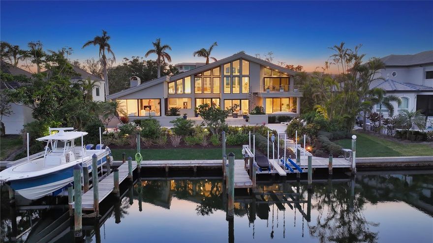 This impeccably updated waterfront residence in the prestigious Bay Isles Harbor neighborhood offers a seamless blend of luxury and coastal charm. Located behind the secure, 24-hour manned gates of Bay Isles, this home has been meticulously enhanced with thoughtful renovations inside and out. Recent improvements include lush new landscaping (2024), impact windows (2018), a renovated family room, kitchen, bathroom, and laundry room (2021), all new air-conditioning systems (2021/24),custom built-ins in the primary suite’s walk-in closets (2024), resurfaced deck, swimming pool, and spa (2015), new pool heater and variable speed pump (2023), new boat lifts (2013), and a tile roof (2011). Spanning over 4,200 square feet, the interior welcomes you with double doors that open to soaring cathedral ceilings and floor-to-ceiling impact glass, creating a dramatic entry filled with natural light. The living and dining areas offer stunning views of the newly resurfaced pool deck and the tranquil waters beyond. The chef’s kitchen is designed for both style and function. Quartz countertops, a five-burner gas cooktop, stainless steel appliances, double built-in ovens, and shaker-style cabinetry provide the perfect culinary setting. Overlooking the family room, this space is enhanced by bay window bench seating, ideal for informal dining. The family room features custom built-ins, a double wine cooler, gas fireplace, and tongue-and-groove ceiling, with glass sliders leading to the Florida Room for additional versatility. All bedrooms are en-suite, ensuring privacy and comfort. Two guest suites are located on the first floor, separated by a private den, with the east-facing suite offering direct pool access. The second floor is dedicated to the primary suite, complete with an oversized loft featuring a built-in office and wet bar. Through double doors, the secluded bedroom opens to a private waterfront terrace with a spiral staircase leading down to the pool deck. The suite also includes dual walk-in closets with custom storage, dedicated vanity area, and marble en-suite bathroom. Designed for effortless outdoor living, the exterior is an entertainer’s dream. The expansive pavered pool deck offers multiple lounging and dining spaces, surrounding a resurfaced heated swimming pool and spa. Boaters will appreciate the 100+ feet of waterfront, multiple docks, 16,000-pound lift, and direct, unobstructed access to Sarasota Bay. As a Bay Isles resident, exclusive membership to the Bay Isles Beach Club provides private beach access just a short bike ride away. Nearby, the Longboat Key Club offers an unparalleled resort-style experience (requires membership), with championship golf courses, award-winning tennis facilities, a Gulfside pool deck, a state-of-the-art fitness center, spa services, fine dining, and a full-service marina catering to boating enthusiasts. Combining sophisticated design with a coveted waterfront location, this remarkable residence delivers the ultimate in coastal luxury.