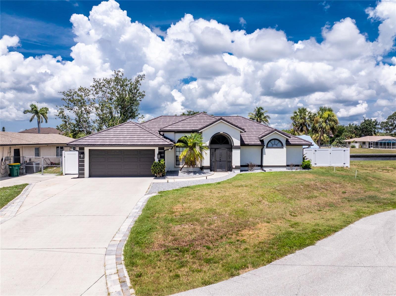 Impressive WATERFRONT home offers boating access to Charlotte Harbor and the Gulf of Mexico. Less than 10 minutes and only one bridge. 95 foot concrete seawall, concrete dock, davits and 4000 lb boat lift. This light and bright home has beautiful design features throughout. It is located in a cul-de-sac and offers an open and split bedroom floor plan, 3 Bedrooms, 2 Bathrooms, 2 Car Garage, Living Room, Dining Room, Family Room, well appointed Kitchen, Inside Laundry and screened Lanai. The Dining Room has a large window with arched window above it. The Living Room offers a cathedral ceiling, plant shelves and sliding glass door to the lanai. The Kitchen features wood cabinets, granite counters, tile backsplash, breakfast bar and stainless appliances. Appliances include side by side refrigerator, dishwasher, oven /range with gas burners (propane fuel) and range hood. There is an area off the kitchen that can be accessed by sliding glass doors. It has cabinets and under counter refrigerator perfect fo your guests. The Kitchen opens to the Family Room with tile flooring, cathedral ceiling and plant shelves. There is an Inside Laundry Room with washer, dryer and cabinets. The Master Bedroom suite features Lanai access, vaulted ceiling and private bathroom with dual sinks, garden tub, arched window and walk in shower. There are two generous sized guest bedrooms with double closets and the guest bathroom has a walk in shower. Your living space extends to the large screened lanai with spacious covered area, inground pool and plenty of deck for sunbathing. Your living space extends to the waterfront as the backyard also has a pergola, a deck at the waterfront, storage shed for your boating equipment and large paver patio which also 0ffers open storage. New Steel roof-weather proof, wind, storm, fire proof, 50 year warranty - 2024, Updated pool deck - 2025, LED pool light, Hurricane proof garage door - 2023, Hurricane shutters, New updated master and guest bathroomsNew AC - 2024, New pool heater - 2024, New gutters - 2024, New Fence - 2024, New sidewalk - 2024, New patio/area to store boat - 2025- approx 850 sq ft, New flooring in all bedrooms. Most of the ceiling fans and light fixtures have been replaced. Laundry room has been updated and seller put in a snack bar. Irrigation system has been updated. Other features include screened front entry, double door entry with transom window, rain gutters, hurricane shutters. NO HOA. This home is minutes from shopping, dining, medical care, waterfront parks.