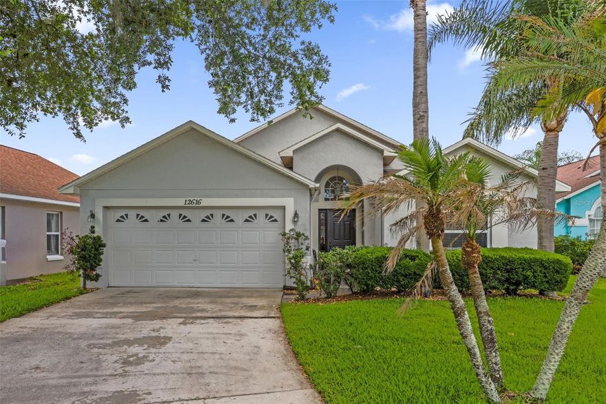 Welcome to this single-story home in Heritage Place offering a bright, open concept layout with vaulted ceilings, neutral finishes, and abundant natural light throughout the main living spaces. The spacious living room features built-in display shelving, tile flooring, a ceiling fan, and sliding glass doors that create easy indoor-outdoor living with access to the screened lanai. The dining area sits just off the main living space and connects comfortably to the kitchen, making the floor plan feel open and functional. The kitchen offers white cabinetry, dark countertops, a pantry, breakfast bar seating, and a convenient view into the dining and living areas. The primary suite provides a relaxing retreat with a ceiling fan, a walk-in closet, and an en suite bath featuring dual sinks, a soaking tub, and a separate tiled shower. Additional bedrooms offer flexible space for guests, work-from-home needs, or hobbies. Outside, enjoy a covered screened lanai overlooking the backyard, plus attractive curb appeal with mature landscaping and a two-car garage.