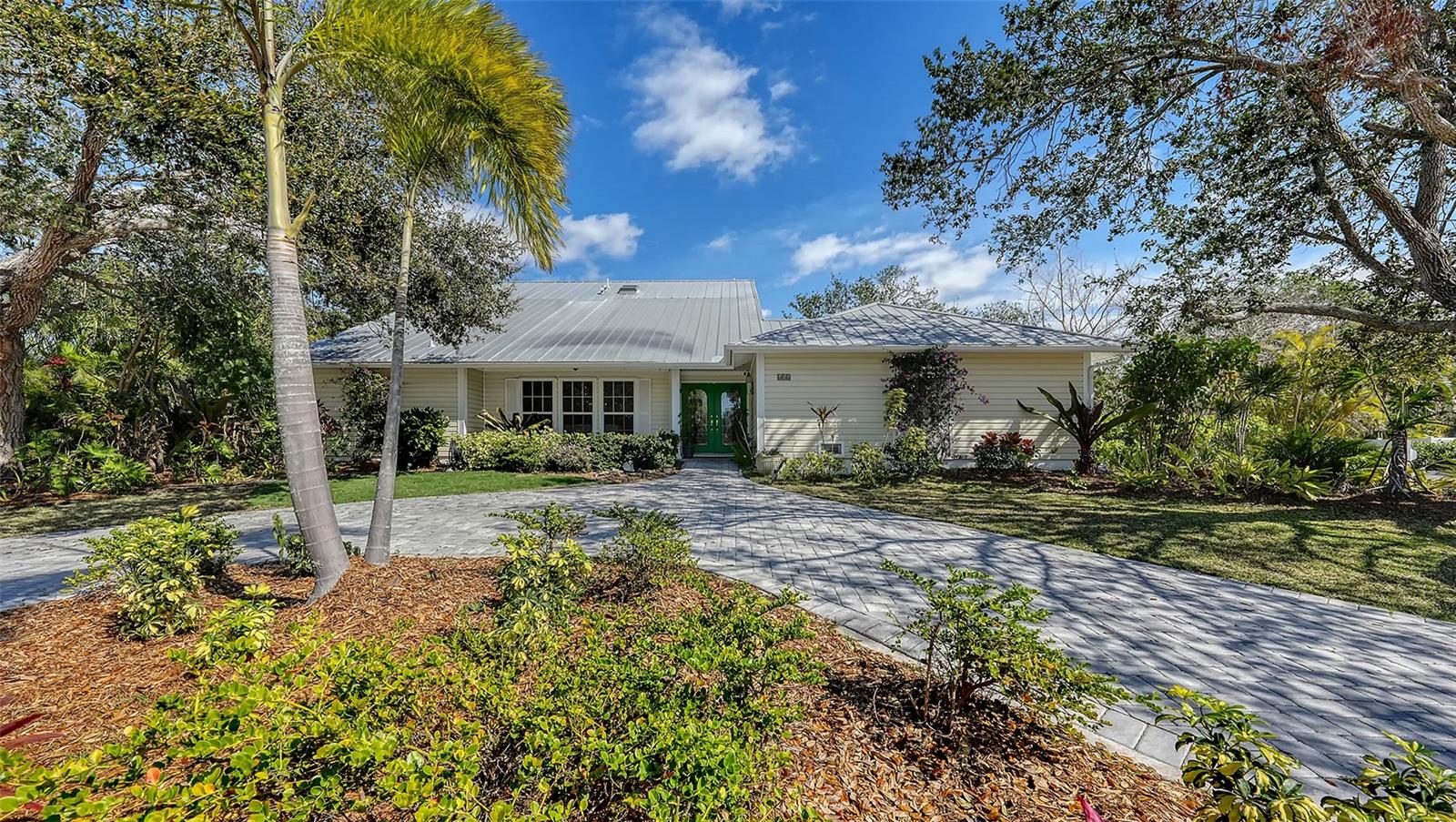 Lovingly owned for 20 years, this tropical retreat offers privacy, charm, and thoughtful updates throughout. Recent enhancements include lush Areca palms for a private, resort-style setting, and an expanded pool area complete with a cozy seating space, large umbrella, and fire pit-perfect for relaxing or entertaining under the stars. Nestled in the heart of Siesta Key, and close to one of the best beaches in the U.S., this spacious 5-bedroom, 3.5 bathroom home offers a perfect blend of comfort, style, and functionality. Featuring engineered hardwood floors throughout, this residence is designed for family living and entertaining. The living room flows seamlessly into the dining room, which is conveniently located next to the kitchen. The kitchen features shaker style cabinetry and Corian counters. A pass-through window and breakfast bar open to the casual dining area, which can easily be transformed into a game room or flex space to suit your needs. On the other side of the of the kitchen is the spacious family room, with soaring vaulted ceilings and fireplace. A French door from the family room leads to the open pool area. A fiberglass salt water pool was added in 2008 with a travertine deck. The spacious Primary bedroom suite includes a sitting area with large window that offers serene views, an adjoining library/office that allows for work from home with floor to ceiling bookshelves with a separate exterior door. A major renovation in 2014 added two additional upstairs bedrooms bringing the total to four, plus a half bath with a charming turquoise/green tile display on the mirrored wall. The full bath upstairs has Quartz counters, shaker cabinets, double sinks, and skylight in the shower giving the space an abundance of natural light. The home is built for durability with a metal roof, hurricane impact windows upstairs, and many downstairs, with custom hurricane Fabric shields protecting non-impact windows and doors. The 10’ elevation has kept the property free from hurricane damage. The home is ideally situated a short distance from Glebe Park, one of Siesta Key’s hidden gems. Perfect for families and active lifestyles, the park features a baseball field, basketball court, multi-purpose field(great for soccer or casual games), pickleball court, playground, restrooms, and a gazebo for parties and picnics. The mid-island location offers easy access to both the North and South bridges.