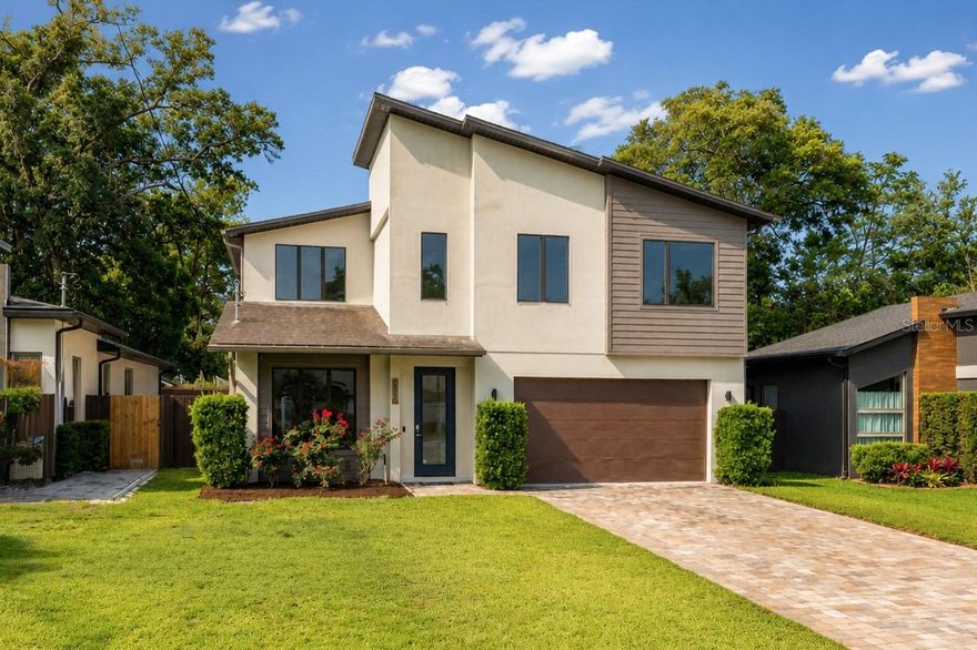 One or more photo(s) has been virtually staged. Custom built in 2019 and zoned for A-rated Boone High School, this nearly 3,000 square foot home offers 4 bedrooms, a dedicated ground-floor office, 4.5 bathrooms, and no HOA — minutes from Downtown Orlando, SoDo, the Hourglass District, and Orlando Health Hospital . The dining room and foyer feature nineteen-foot soaring ceilings that draw light and scale throughout the space. Oversized windows, eight-foot doors throughout, and elegant finishes flow seamlessly from room to room. The kitchen includes exotic granite countertops, custom cabinetry, premium KitchenAid stainless appliances, and new pendant lighting above an oversized island. A water filtration system provides pure drinking and cooking water. The main level includes a full bedroom with ensuite bathroom, ideal for guests or multigenerational living, plus a dedicated ground-floor office for the work-from-anywhere lifestyle. Every closet features custom built-in shelving and motion-sensor lighting for convenience. Upstairs, the primary suite includes a spa-inspired bath and 2 generous walk-in closets. Two additional guest bedrooms and a loft upstairs  provide flexibility for family, guests, a home gym, or studio space. The fully-fenced backyard with custom landscape lighting is ready for entertaining. Location is unmatched: walk to Lake Como Park, bike to dinner. Newer 2019 systems, septic serviced in 2026, flood zone X with flood insurance typically not required, and insurance-friendly age provide peace of mind. Schedule a showing today!