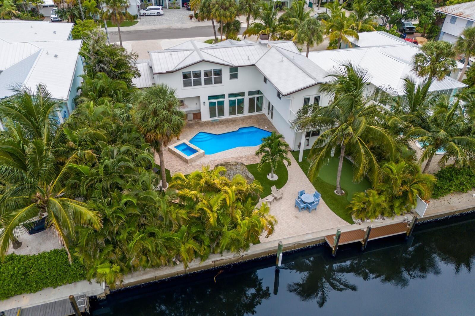 STUNNING RENOVATED 5 BEDROOM POOL HOME ON A DEEP WATER CANAL ONLY STEPS FROM THE BEACH!!! Nestled on the highly coveted north end of Anna Maria Island, this beautifully renovated and turnkey furnished 5-bedroom, 5-bathroom home spans 3,844 sq. ft. of luxurious living space. Perfectly situated on a deep-water canal with direct Gulf of Mexico access, this home is a dream for boating enthusiasts while also being just moments from the island’s pristine beaches. Upon entering, you’ll be greeted by a flood of natural light, creating a bright and airy atmosphere that welcomes you into this thoughtfully designed home. The living room offers ample seating and flows seamlessly into the adjacent dining room, where elegance meets functionality. With light flooring and coastal tones throughout, the home exudes a relaxed yet sophisticated vibe. The dining room opens easily to the kitchen and outdoor pool area, making it an ideal space for entertaining. The gourmet kitchen is a chef's delight, featuring quartz countertops, custom cabinetry, stainless steel appliances, and a cozy breakfast bar. From the living room, large sliding glass doors provide effortless access to the pool, creating a perfect blend of indoor and outdoor living. The first floor hosts three spacious bedrooms, each with excellent closet space, and three beautifully updated bathrooms, all exuding modern elegance. The expansive game room and laundry area combine fun and practicality, equipped with two washers and dryers, a second refrigerator, ample cabinetry, and a ping-pong table. Whether you’re hosting family or friends, this well-designed layout provides comfort for all. Upstairs you will find an additional two bedrooms and two bathrooms with an outdoor deck overlooking the canal. Renovated in 2023 and 2025, this home boasts an array of high-end upgrades including new appliances, new flooring, remodeled bathrooms, new lighting and fans, an outdoor kitchen, a new electric fireplace, freshly painted interiors and exteriors, new patio sliders, new putting green, a new front entrance door, and updated back doors. Step outside into the breathtaking backyard, and you'll instantly be transported to your own private tropical retreat. The heated salt water pool and spa invite relaxation, while the outdoor kitchen, covered cabana with a dining area, tiki hut, and hammock offer multiple options for entertaining or unwinding. The putting green and dock complete this outdoor haven, where you can fish, relax, or simply enjoy the island lifestyle. Deep water canal with no bridges to the Bay, ICW and Gulf of Mexico. This home is an exceptional investment opportunity, benefiting from a transferable BERT HARRIS ACT RIGHT, ALLOWING SHORT-TERM RENTALS FOR UP TO 12 GUEST--a rare and valuable advantage. With a proven rental history, this property appeals equally to investors and those seeking a tranquil personal retreat. Every detail has been meticulously curated to create the perfect island home. Ideally located, this home is just a short stroll to the Anna Maria City Pier and the charming shops and restaurants along Pine Avenue. Whether you're looking for the ultimate vacation getaway or an income-generating property, this is truly a slice of paradise on Anna Maria Island. These photos are pre-renovation. New photos coming soon!