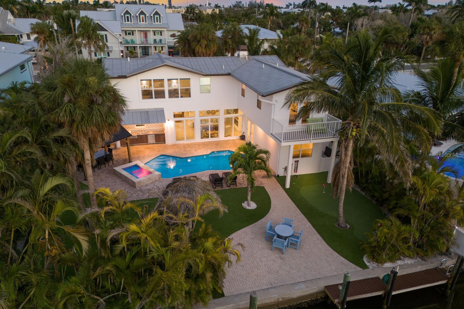 STUNNING RENOVATED 5 BEDROOM POOL HOME ON A DEEP WATER CANAL ONLY STEPS FROM THE BEACH!!! Nestled on the highly coveted north end of Anna Maria Island, this beautifully renovated and turnkey furnished 5-bedroom, 5-bathroom home spans 3,844 sq. ft. of luxurious living space. Perfectly situated on a deep-water canal with direct Gulf of Mexico access, this home is a dream for boating enthusiasts while also being just moments from the island’s pristine beaches. Upon entering, you’ll be greeted by a flood of natural light, creating a bright and airy atmosphere that welcomes you into this thoughtfully designed home. The living room offers ample seating and flows seamlessly into the adjacent dining room, where elegance meets functionality. With light flooring and coastal tones throughout, the home exudes a relaxed yet sophisticated vibe. The dining room opens easily to the kitchen and outdoor pool area, making it an ideal space for entertaining. The gourmet kitchen is a chef's delight, featuring quartz countertops, custom cabinetry, stainless steel appliances, and a cozy breakfast bar. From the living room, large sliding glass doors provide effortless access to the pool, creating a perfect blend of indoor and outdoor living. The first floor hosts three spacious bedrooms, each with excellent closet space, and three beautifully updated bathrooms, all exuding modern elegance. The expansive game room and laundry area combine fun and practicality, equipped with two washers and dryers, a second refrigerator, ample cabinetry, and a ping-pong table. Whether you’re hosting family or friends, this well-designed layout provides comfort for all. Upstairs you will find an additional two bedrooms and two bathrooms with an outdoor deck overlooking the canal. Renovated in 2023 and 2025, this home boasts an array of high-end upgrades including new appliances, new flooring, remodeled bathrooms, new lighting and fans, an outdoor kitchen, a new electric fireplace, freshly painted interiors and exteriors, new patio sliders, new putting green, a new front entrance door, and updated back doors. Step outside into the breathtaking backyard, and you'll instantly be transported to your own private tropical retreat. The heated salt water pool and spa invite relaxation, while the outdoor kitchen, covered cabana with a dining area, tiki hut, and hammock offer multiple options for entertaining or unwinding. The putting green and dock complete this outdoor haven, where you can fish, relax, or simply enjoy the island lifestyle. Deep water canal with no bridges to the Bay, ICW and Gulf of Mexico. This home is an exceptional investment opportunity, benefiting from a transferable BERT HARRIS ACT RIGHT, ALLOWING SHORT-TERM RENTALS FOR UP TO 12 GUEST--a rare and valuable advantage. With a proven rental history, this property appeals equally to investors and those seeking a tranquil personal retreat. Every detail has been meticulously curated to create the perfect island home. Ideally located, this home is just a short stroll to the Anna Maria City Pier and the charming shops and restaurants along Pine Avenue. Whether you're looking for the ultimate vacation getaway or an income-generating property, this is truly a slice of paradise on Anna Maria Island.