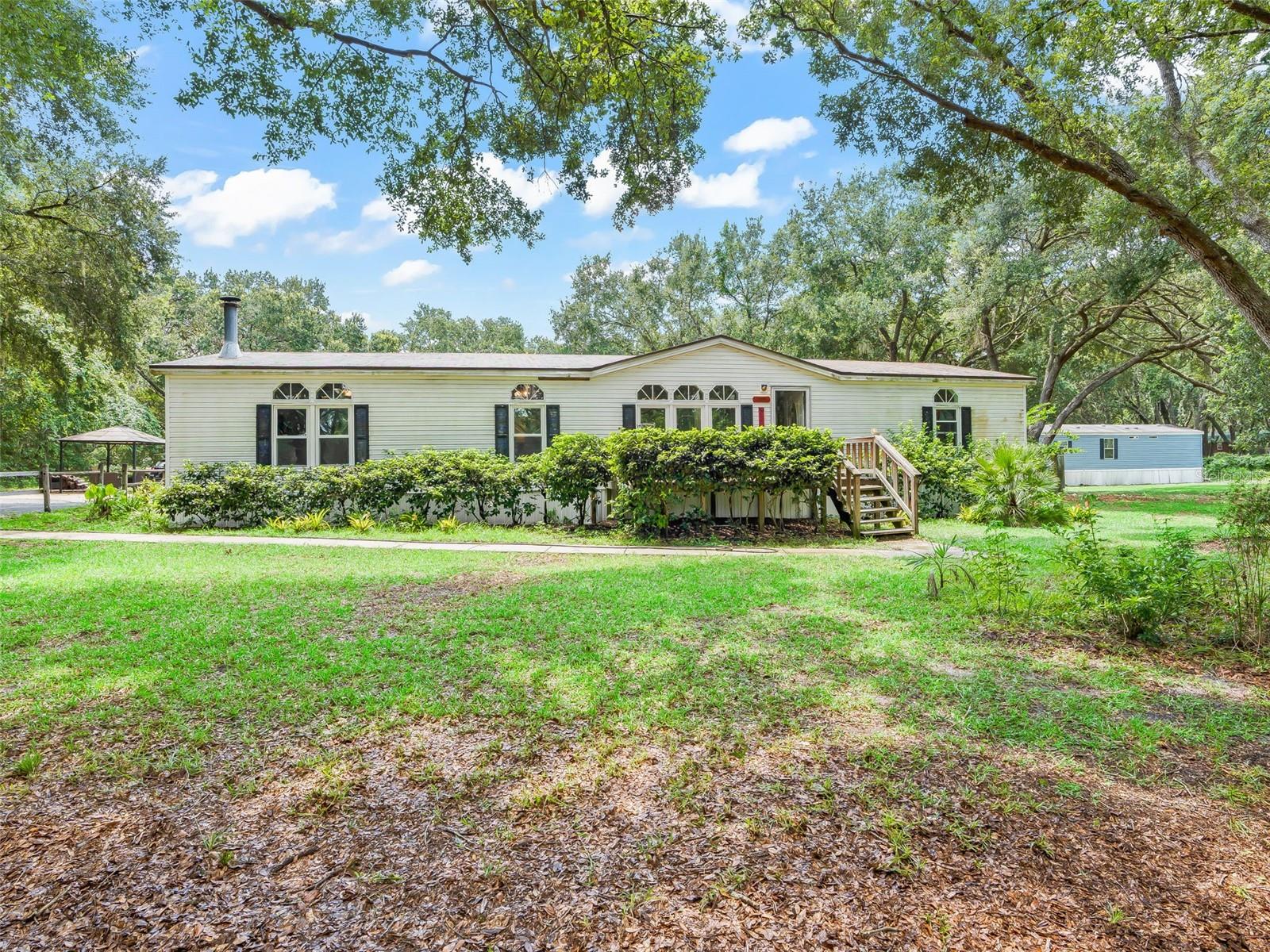 **GREAT DEAL**!! 2 HOMES being sold together in the lovely Countryside Lakes, a quiet, quaint, Deed Restricted, Horse/pet friendly Community close to The Villages and the Ocala National Forest. The main home is a 1999 3/2 Double wide-open floor plan with plenty of space and privacy; it has that cozy 'down home' feel and a perfect place to call your new home! Enjoy the outdoors year-round in the fully screen enclosed back porch overlooking the pond, mature landscaping and gorgeous grandaddy Oak trees. This is nature at its finest!  The 2nd home is a 2020, 2 bed, 2 full baths, single wide Mobile home & could be used as a Mother-in-Law Suite or for a Rental. The entire property is fenced & completely adequate for dogs, horses, or other pets. The Shed in back could easily be converted into a pet shelter or perfect for housing lawn equipment, etc. The wonderful thing about living in this area is the feel of seclusion and peace, yet it is just minutes away from Shopping, Restaurants, I-75 & more!