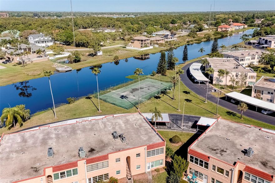 Welcome to the Gardens, a 55+ community located adjacent to the beautiful Lake Seminole Park with its own private entrance. Enjoy biking, walking, and fishing along the miles of trails within the park. The Gardens offers a peaceful setting and is rich with amenities such as a heated pool, tennis and pickleball courts, shuffleboard and a clubhouse with large screen TV, pool table, BBQ grills and a full service kitchen. The complex was not flooded by the recent hurricanes and has no assessments for repairs. This unit has 2 covered parking spots directly in front of the unit. The carports were recently upgraded several years ago. The Condo association has just completed installing a new roof [August 2025], again no assessments. The Condo association provides for lawn care, internet with cable, water, sewer and garbage and building exterior maintenance. The interior has 2 bedrooms and 2 baths with newer windows and is bright with natural lighting. The AC is also newer. The washer and dryer are included in the sale. This condo comes partially furnished and is ready for occupancy whether it be for full time use, second home or income producing. Call today for your private tour - you'll be glad you did!