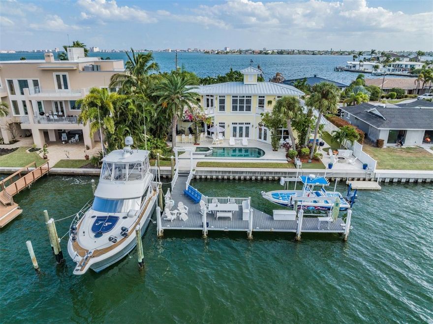 A REMARKABLE LUXURY WATERFRONT LIVING EXPERIENCE, LOCATED IN THE HEART OF ST. PETE BEACH! Brilliantly rebuilt with extraordinary attention to detail, you’ll be captivated by the lavish Key West style home with two Primary Suites.  Both suites are waterfront, one on each floor.  A rich curb appeal introduces a dazzling residence with high ceilings, and sweeping views of the waterfront. The splendid open floor plan transitions to a NEW (2022) Chef’s Kitchen with fine white custom cabinetry, magnificent granite counters and tile backsplash, Viking eight burner gas range with double ovens, Viking side-by-side refrigerator, Viking stainless-steel appliances, and a large center island bar/prep center. The spacious waterfront living room is complemented by separate formal & casual waterfront dining areas. Main living level offers a plush, private primary suite w/luxurious full bath, 2 additional bedrooms and an elegant guest pool bath. Beyond the living areas, you’ll be called to an astonishing waterfront paradise: A large outdoor kitchen area with finished ceilings, generous covered bar area and an impeccable outdoor kitchen.  Enjoy a built-in gas grill as well as a Green Egg Grill, sink, refrigerator and three large TVs for fabulous waterfront watching of sporting events!!  An eye-catching pool/spa with LED lighting is enveloped striking shellstone pavers, with ample lounging space. The upper “owner’s” level is luxuriant and deeply satisfying! The executive office overlooks the waterfront and has two adjacent balconies with both southern and northern views of the water. Step into the owner’s suite and be swept away by its privacy, size, beauty, and refinement. Do not miss the upstairs laundry adjacent to the owners suite. The upper level bath is pampering and lavish - with gorgeous granite vanities, dedicated cosmetics center, soothing soaking tub & spectacular walk-in shower. A large closet features custom closet systems that will please the most demanding clothier. Step out to the owner’s balcony and take in the soothing views of the waterfront and sunsets over St. Pete Beach!  The seawall was updated and raised, as was the composite dock, and there is a deep water slip capable of accommodating a vessel up to 65 feet in length.  Additionally the dock system includes a 10K lb. boatlift & a floating dock for easy access to your kayak or SUP.  Do not miss the gas fire pit, the putting green and the waterfront driving range. The home is also supported by a whole house Generator system that is powered by Natural Gas with Propane Gas backup. This is truly a showcase home - a dynamic waterfront living environment that is move-in ready!!  Call me today for your private viewing.