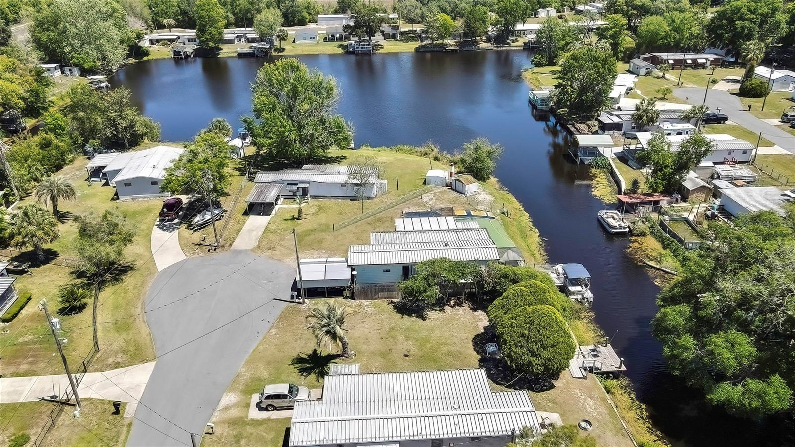 3 BEDROOMS, but only one has closets, therefore county records say 1 br. THIS HOME IS A STEAL! $9k price reduction already! Do not wait for your chance at obtaining this WATERFRONT property with no maintenance turf and a fenced in yard! You'll feel right at home with the many add ons and updates here, including a shed, carport and large, open, covered patio. Take off from your own boat dock and boat through 200 miles of canals and lakes. This neighborhood also has a private boat launch. This affordable gem has so much value! It has a large open kitchen with plenty of cabinets and a great family room to stretch out in after a day on the water! It's close to all of the modern conveniences and restaurants. Second home or main home, come and see this one today! No HOA, park fees or deed restrictions to deal with here. This property is move in ready. Due to the 1965 manufacture date, sale will be CASH ONLY!