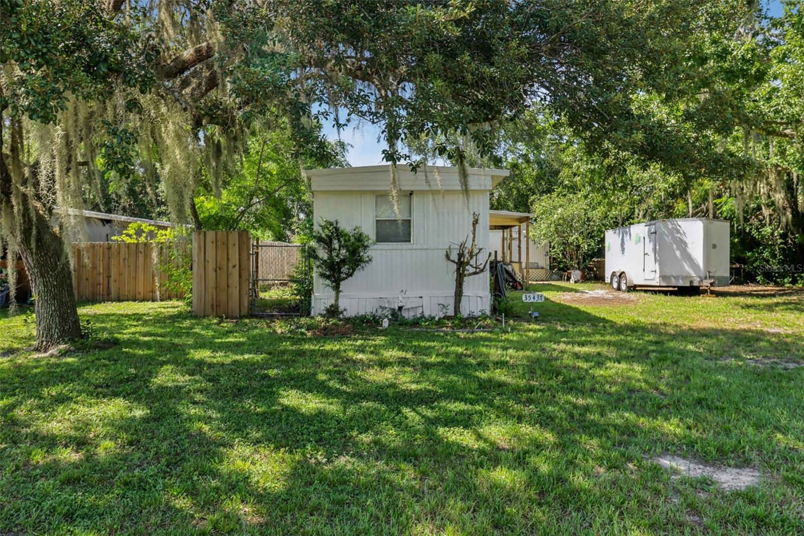THIS 1973 SINGLE WIDE HOME HAS BEEN TOTALLY UPDATED WITH NEW EFFECTIVE DATE OF 1988 BY THE LAKE COUNTY PROPERTY APPRAISER. THIS HOME HAS BEEN REWIRED WITH 200 AMP UNDERGROUND SERVICE, WITH COAX WITH 6 DROPS IN HOME, WITH 100 AMP PANELS IN HOME AND WORKSHOP, REPLUMBED WITH COPPER NO GRAY PIPE, NEW CEILINGS, NEW WALLS, NEW LAMINATE FLOORING THROUGHOUT, INSULATION IN CEILINGS, WALLS AND FLOORS. NEW KITCHEN CABINETS AND BUILT IN SHELVING, LARGE ROLLING ISLAND FOR FOOD PREPARATION. NEW BARN DOORS ON PRIMARY BEDROOM, UPDATED BATH WITH NEW ANTIQUE PEDESTAL SINK AND LARGE SHOWER, ALONG WITH BUILT IN SHELVING, NEWER CENTRAL HEAT AND AIR, ALONG WITH A WINDOW UNIT IN LIVING ROOM, NEWER 40 GALLON HOT WATER HEATER IN STORAGE/WORKSHOP BUILDING (16 X 16) ALL ON .22 ACRES OF LAND, FENCED WITH A WELL, SEPTIC TANK AND WATER FILTRATION SYSTEM. ALL THIS AND NO HOA. MAKE YOUR APPOINTMENT TODAY TO SEE THIS HOME!