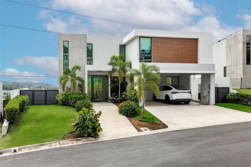Welcome to MonteAzul, the luxury new development within the prestigious Montecielo community in Guaynabo—designed for modern living, privacy, and comfort. This exclusive gated neighborhood offers a resort-style lifestyle with 24-hour security, a stunning infinity pool, luxury fitness center, pickleball and tennis courts, landscaped recreational spaces, and a family-oriented atmosphere. As part of a new development, the property also benefits from no property taxes, creating exceptional long-term value.
This newly constructed residence features a spacious and functional layout with 4 bedrooms and an elegant open-concept design that seamlessly connects the living, dining, and kitchen areas. Expansive windows fill the home with natural light while showcasing the property’s beautiful mountain views and surrounding greenery.
Designed to maximize outdoor living, the home includes a private pool, terrace, and large yard, creating the perfect setting for entertaining family and friends or simply enjoying Guaynabo’s year-round tropical climate. The property is also fully equipped with a full generator, water cistern, and electric vehicle charging plug, offering convenience and peace of mind rarely found in newer homes.
A rare opportunity to own a modern, fully equipped residence in one of Guaynabo’s most sought-after luxury communities.