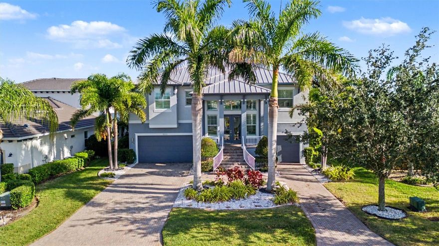 Stunning, fully updated RIVER VIEW home in the premier boating community of Tidewater Preserve! This MOVE-IN-READY 3 ensuite bedroom + den, 3.5 bath, 3-car garage, pool & spa residence offers nearly 4,000 sq ft of refined living space with breathtaking long-range Manatee River views from both levels. Freshly painted inside and out, the home showcases exceptional curb appeal with a circular driveway, METAL ROOF, split 3-car garage, HURRICANE-IMPACT windows and doors, upgraded landscaping, and an impressive double staircase that sets the tone for the luxury within. Plantation shutters enhance every room, complemented by remote-controlled blinds in the living room and primary suite. Inside, an elegant OPEN FLOOR PLAN features tile flooring throughout, soaring ceilings, designer lighting, surround sound, and a dramatic decorative tile feature wall highlighting a 96-inch fireplace. The gourmet kitchen boasts a 48-INCH stainless commercial 6-burner gas cooktop with griddle and commercial exhaust hood, CAMBRIA quartz countertops with a waterfall island, full-height Cambria backsplash, Cambria-wrapped island front, custom cabinetry, walk-in pantry, stainless steel appliances, built-in oven, and a wine cooler encased in a Cambria waterfall surround. A separate built-in bar further elevates the main living area—perfect for entertaining. The den features unique architectural appeal with three custom cutout arches with Cambria quartz sills and a built-in cabinet topped with Cambria quartz. The upper-level primary suite captures sweeping river views and includes two custom walk-in closets and a spa-like bath with double sinks, soaking tub, walk-in shower, and Cambria quartz counters and finishes. A convenient upper-level half bath is ideal for guests. The lower level offers two ensuite guest bedrooms and an additional living area—perfect for extended family, teens, or visitors seeking privacy. Both guest suites feature beautifully updated baths with matching cabinetry, Cambria quartz countertops, and quartz-framed mirrors. Outdoor living is exceptional with 36' x 12' upper and lower covered porches, a spacious screened pool deck, and a fully automated saltwater pool and spa. The impressive two-story panoramic screen enclosure captures unobstructed river views and includes an outdoor kitchen, safety baby gate, and exterior Ring cameras. A custom spiral staircase seamlessly connects both levels for effortless indoor-outdoor enjoyment. Tidewater Preserve offers unmatched amenities, including a private marina accommodating boats up to 32 feet, clubhouse, two fitness centers, three pools, tennis courts, kayak launch, dog park, scenic riverfront walking trails, and 24-hour guard-gated security. Red Storage cabinets in garage included.