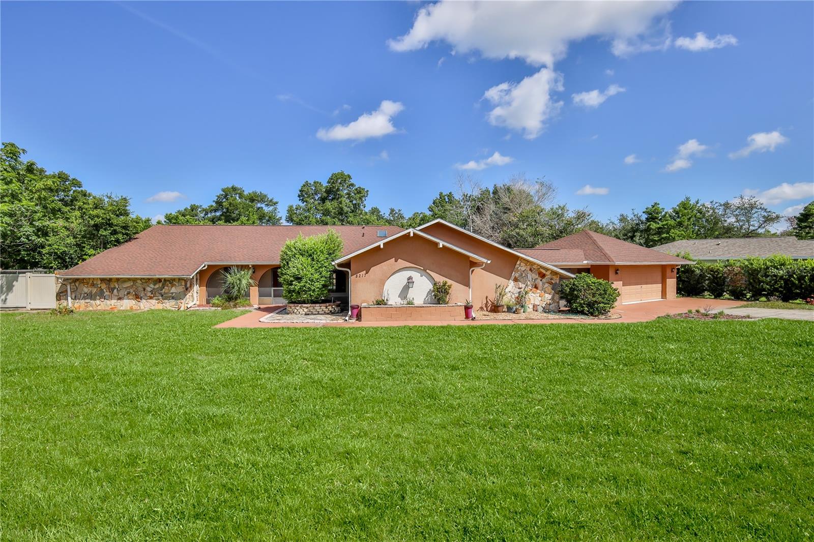 One or more photo(s) has been virtually staged. This incredible spacious home sits on .52 acres and has 2,8974. sq. ft. of living space. Located in upscale Community this home boasts 3 large bedrooms, step down living room with center stone fireplace, wet bar, real wood floors with sliders on both sides with views of the pool.
Primary bedroom has slider as well with walk-in-closet and bath with dual vanities and walk-in-shower. In addition, formal dining room and large den surround the living room. Ceramic tile walkway and secondary bedrooms have brand new luxury vinyl flooring. Beautiful custom kitchen with real butcher block, pull out drawers in island for convenience. There is a bonus room with walk in closet for storage and a decent sized work shop. The bonus room is huge, perfect for a playroom, yoga/pilates workout room and you can go through the screened in breezeway to the oversized garage or to the open patio with fountain to the screened in pool. The heated pool and hot tub area are great. Huge deck for entertaining, outdoor kitchen with brand new mini fridge. Enjoy the Florida Lifestyle. Gutters and downspouts,