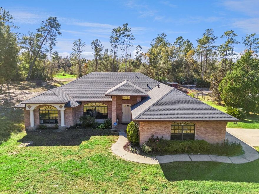 One or more photo(s) has been virtually staged. Set on a secluded, oversized 2.62-acre corner lot with NO HOA, this 3-bedroom, 2-bath home offers exceptional privacy, space, and versatility. Tucked away and only visible from the driveway, the property provides a truly private setting—perfect for those seeking peace and room to spread out. Whether you need space for toys, hobbies, or future expansion, this property delivers in a big way. The standout feature is the two-garage setup: a 2-car attached garage plus an impressive 1,200-square-foot detached garage/workshop. Designed for serious functionality, the detached garage includes a 11,000-lb car lift, two roll-up garage doors, and a large 12' x 12' entrance, making it ideal for car enthusiasts, contractors, storage, or anyone needing substantial workspace. The expansive acreage offers endless possibilities for outdoor living, RV or boat parking, or simply enjoying the privacy of your own land. Major upgrades provide peace of mind, including a new roof (2024), AC (2020), water heater (2025), and recently pumped septic tank (2025). Inside, the home features a thoughtfully designed layout with a separate living room, family room, dining room, and breakfast nook—providing flexibility for everyday living and entertaining. The kitchen is well-appointed with granite countertops, stainless steel appliances, and ample storage. The primary suite is a true retreat with tray ceilings, dual closets, dual vanities, a soaking tub, and a walk-in shower. Step outside and enjoy Florida living year-round in the screened-in pool, perfect for relaxing or hosting guests. Centrally located with convenient access to I-4, shopping, dining, Daytona beaches, and Orlando attractions, this property combines privacy, functionality, and convenience—a rare opportunity on a truly private, oversized lot. Schedule your private showing today!