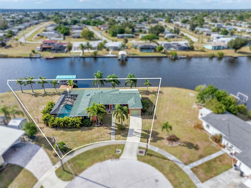 Oversized Gulf-access tip lot with nearly 200 ft of waterfront and wide canal views! This 3BR, 2BA heated pool home with to many upgrades to mention, sits high & dry in the heart of Port Charlotte. Enjoy the seawall, dock with covered lift,  Bright open great-room plan with high ceilings and water views from most rooms. Split bedroom layout: private primary suite plus two spacious guest rooms. Home partially furnished. Extra-wide canal offers about a 12-minute ride to Charlotte Harbor and the Gulf. City water/sewer. Sidewalks to 2 local parks and close to beaches, boating, dining, shopping, medical and Punta Gorda Airport. Florida waterfront living at its best!