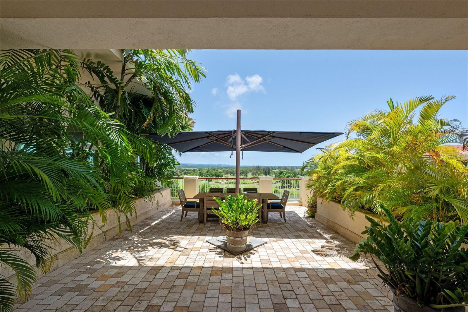 This beautifully furnished two-story penthouse offers a seamless blend of refined style and everyday comfort. With approximately 3,706 square feet of interior space and 4,744 square feet including expansive covered terraces, this residence is thoughtfully designed for elevated, turnkey living. The main level welcomes you with an open-concept layout that flows effortlessly from the entryway into spacious living and dining areas, framed by soaring ceilings and a well-equipped kitchen. Two generously sized bedrooms, each with custom closets and private en-suite baths. A guest powder room, laundry room, and additional storage complete this level. Upstairs, a versatile loft space features a built-in bar with icemaker, two beverage fridges, a second powder room, and two additional bedrooms, currently arranged as a serene principal suite and a dedicated home office. Each includes its own en-suite bath. The private rooftop terrace invites relaxation, offering both covered and open-air lounge areas, a jacuzzi, and sweeping views of the lush driving range and surrounding mountains. Additional highlights include a two-car garage, two exterior parking spaces, and a prime location in the heart of the Resort, just moments from the Clubhouse, Fitness & Wellness Center, Sports Hub, and The Watermill. This is an exceptional opportunity to own a fully furnished, move-in-ready penthouse within one of the Caribbean’s most desirable resort communities.