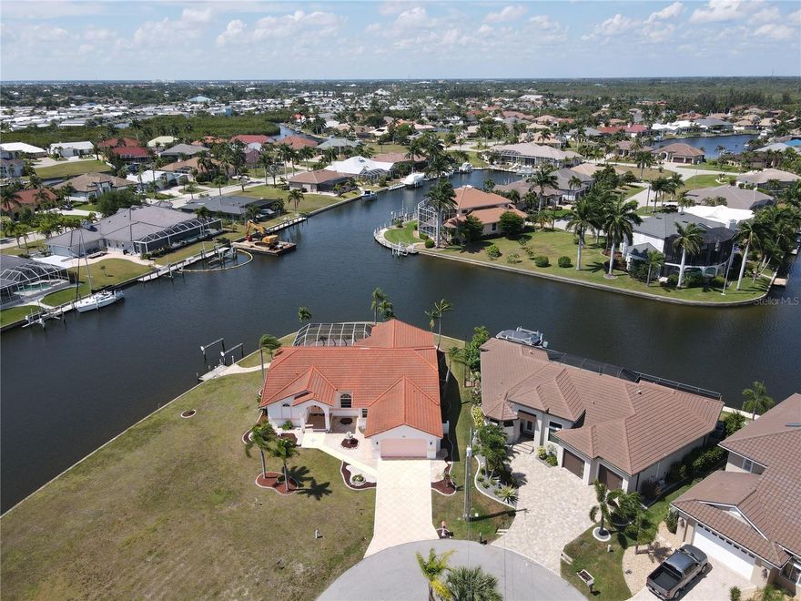 TIP LOT ALERT!! This home has 185 ft. of seawall on emerging canal fronts that give you an amazing view 24 hours a day. This lot is as good as it gets in Burnt Store Isles. Plus this home has an assumable Flood Insurance Policy of only $1307 a year.  At 2868 sq. ft. this home has it all. As soon as you walk into the foyer, all you see is a huge heated pool with a spa and a gorgeous water view.  What a start, then you have a formal dining area and living area combined on one side of the house and then a huge 23 x 22 family room that combines with a dinette by the kitchen.  A large Primary bedroom with a walk out and view of the pool area and the canal front.  The primary has his and her walk in closets and the bathroom has a walk in shower with a sit alone tub. His and her sinks finish off the bathroom. Both the 2nd bedroom and the 3rd bedroom have walk in closets as well which is hard to find.  The pool area has a brick paver decking and is a Pebbletec finished pool that measures in at 13 x 28. A pool bathroom with a stand up shower makes for total convenience as well. This entire area is great for entertaining as the undercover lanai area is an additional 11 x 24.  Higher vaulted ceilings and plenty of slider door walls and windows out back make it feel as if you on the water all day long. Another nice extra is an office that measures in at 11 x 13.  Entry to the lanai and pool area can be made by way of the family room, living room, dinette and the primary bedroom. A large brick paver patio is just outside of the lanai area and is perfect for toasting marshmallows and having a few drinks. You always hear the saying, Location, Location, Location and this home has it.  At the entrance of the neighborhood is a Publix Shopping Center with restaurants and many other businesses.  Home Depot is right next door to Publix.  A Walgreens is on the entrance street to the neighborhood and Walmart is just minutes away.  But just as important is that downtown Punta Gorda is just minutes away with all the dining options that one could ask for.  From high end cuisine restaurants, to great breakfast places and of course, your favorite pubs or sports bar.  So many historical things to see when you browse around town and walk along the miles long walking and biking path that hugs along the water front.  Enjoy the fan favorite Saturday morning Farmers Market. The downtown Christmas Tree Lighting is a must for any family, as it is a fantastic event. Pickleball courts all around town including the newer Pickle Plex where leagues and tournaments are held year round for all you passionate pickleball lovers. Multiple places around town to put a boat or wave runner in the water and 8 different golf courses within a 20 minute drive of this home including Twin Isles Golf and Country Club that is visible on picture #54 that runs through the neighborhood.  Going to Fisherman's Village and just browsing around and shopping or dining always makes for a nice Sunday afternoon or just take the little ones to the new playground right downtown that looks over the Charlotte Harbor. So hurry now to see this TIP LOT HOME with an amazing view.