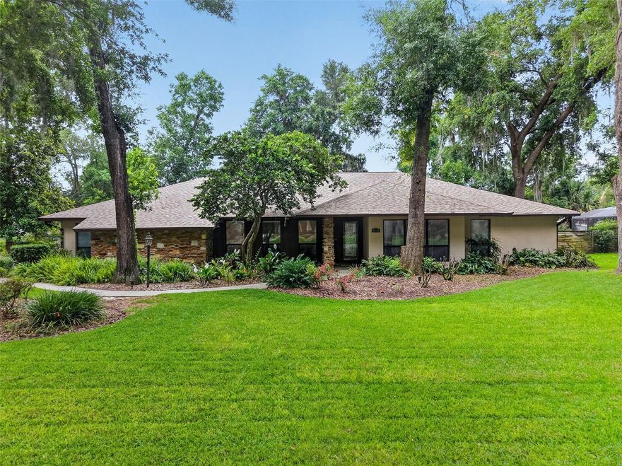 EXCEPTIONALLY PRICED POOL HOME WITH PRIVATE DEN AND OVERSIZED GARAGE IN THE HIGHLY DESIRABLE LAKE FOREST COMMUNITY OF MOUNT DORA. Nestled among manicured lawns and majestic moss-draped oaks, this beautifully maintained residence offers the perfect blend of comfort, privacy, and timeless Florida charm. Situated on an oversized homesite, the property showcases mature landscaping, earthy architectural tones, natural stone accents, and a welcoming curb appeal that immediately feels like home. A long driveway with an additional parking pad and side-entry oversized two-car garage provides ample parking for family and guests alike. A covered front entry and paved walkway create a warm and inviting arrival. Inside, natural light pours through skylights, expansive windows, and sliding glass doors, illuminating vaulted wood-beam ceilings and serene pool views throughout the main living spaces. The thoughtfully designed floor plan balances open-concept living with flexible private spaces, creating an atmosphere that is both elegant and relaxed. A formal living room and separate den/home office offer versatile options for remote work, fitness, hobbies, gaming, or additional entertaining space. At the heart of the home, the spacious family room, kitchen, and dining area come together beneath soaring vaulted ceilings. The kitchen is beautifully appointed with richly stained wood cabinetry, granite countertops, stainless steel appliances, an expansive breakfast bar, poolside dining area, and a large combined walk-in pantry/laundry room. The family room features extensive built-in storage and telescoping sliding glass doors that seamlessly connect indoor and outdoor living. The split-bedroom floor plan ensures privacy for everyone. The generous primary suite serves as a peaceful retreat with a walk-in closet and private en-suite bath featuring dual granite vanities and a tiled shower. Two additional guest bedrooms, both with walk-in closets, share a beautifully updated guest bath with granite vanity and tiled tub/shower combination. Storage is abundant throughout the home, including generous closets, a dedicated laundry/storage room, attached utility shed, and oversized garage. Recent improvements include the water heater (2026), pool heat pump, and the roof, A/C and pool screen enclosure were replaced in 2017. Step outside to your private backyard oasis featuring a sparkling screened pool, lush lawn, mature landscaping, and partial privacy fencing — ideal for entertaining or simply unwinding in a tranquil setting. Conveniently located near shopping, dining, and everyday essentials, this home is also just minutes from historic downtown Mount Dora, known for its charming boutiques, waterfront parks, cafes, art galleries, theater, festivals, and marina. Orlando International Airport, Walt Disney World, and Florida’s East Coast beaches are all approximately one hour away. A rare opportunity to enjoy peaceful living, flexible space, and exceptional value in one of Mount Dora’s most desirable communities.