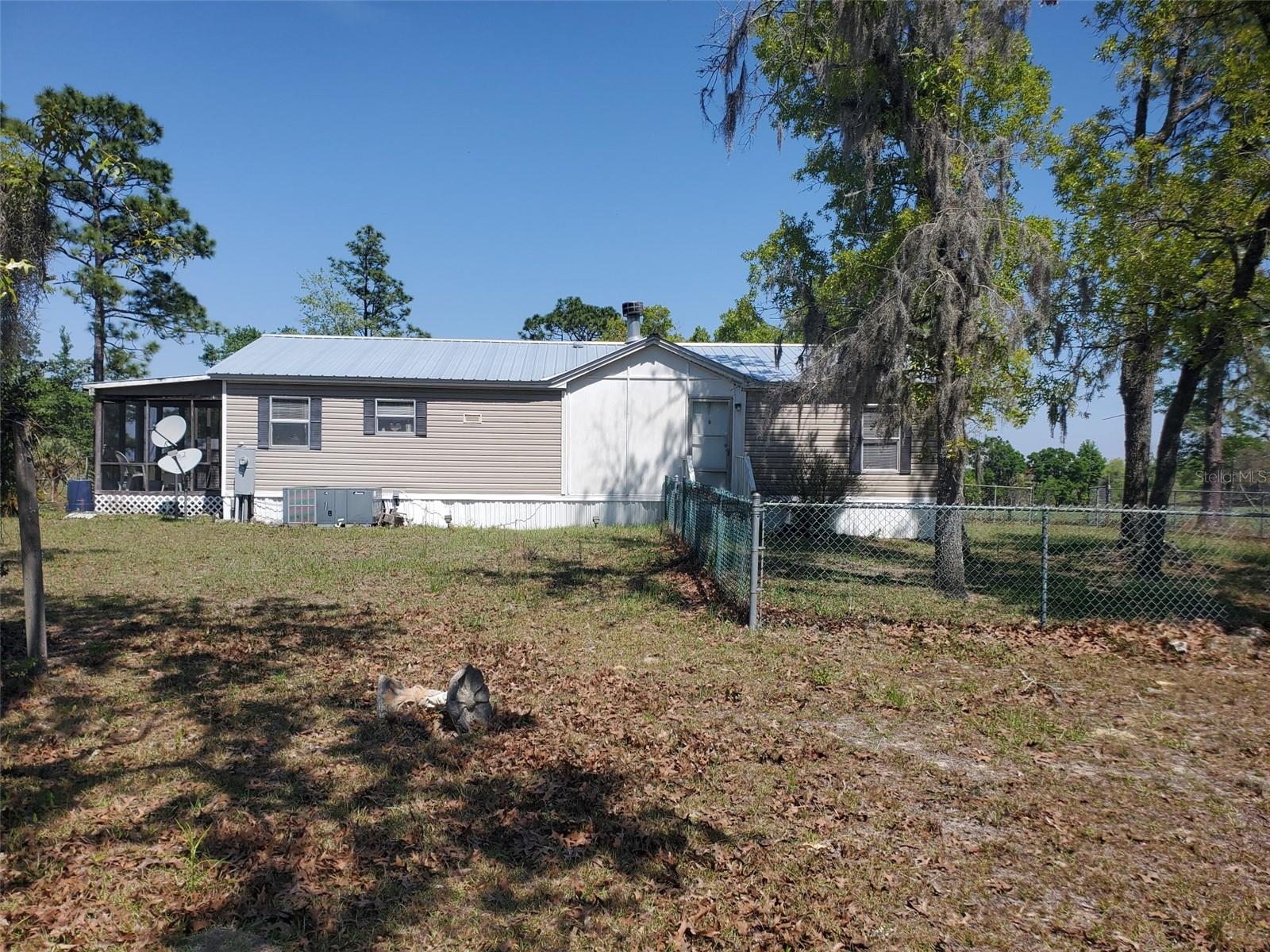 3 BEDROOM 2 BATH HOME ON 8.59 ACRES IN MARION COUNTY! Located just 30 minutes to World Equestrian Center This property is a serene countryside retreat, perfect for those seeking a peaceful and spacious homestead. With over 8 acres of land, including adjacent acreage with potential for a family member's home, it offers ample space for both privacy and communal living. The scenic view of surrounding farmland adds to its charm, creating a picturesque backdrop for everyday life. The presence of essential amenities like an extra well, septic, and power, along with features such as the hay barn, feeding stall, and fencing, make it well-suited for horse or livestock enthusiasts. Additionally, the various outbuildings, including the hay barn, office shed, and storage shed, provide practical solutions for storage and workspace needs. The manufactured home is cozy and inviting, with a thoughtful layout including a split bedroom plan for added privacy. Features like the wood-burning fireplace and ample kitchen space enhance its comfort and functionality. The screened porch, partially open side porch offer ideal spots for enjoying the breathtaking sunsets that grace the property. Overall, this property offers a harmonious blend of comfort, convenience, and natural beauty, making it a desirable place to call home.