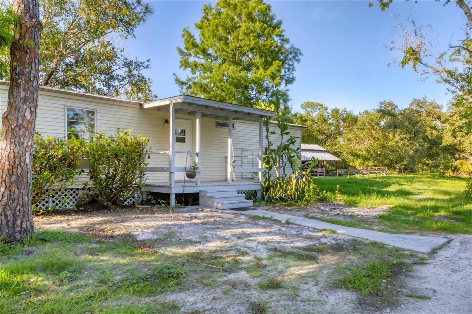 Great Investment on Country Acreage!!! Wonderful 2 bedroom/2 bath home on 8.38 acres in the quiet Countryside of Myakka City. New metal roof was put on home in 2023. Has a 2 Stall horse barn and a second metal roof work barn with electricity. Has a dog run and a Chicken coop as well. Home needs updating.