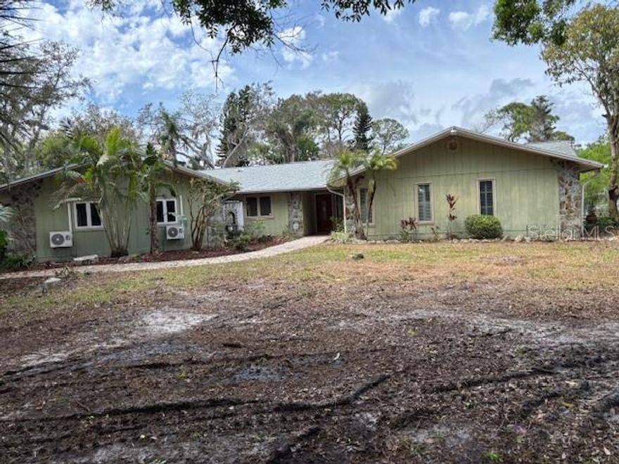 This home has been vacant for a short period of time since the owners passing.  Just over 1 acre of land.  On 225 Ft of canal front.  4 Bedrooms and a 1 bedroom 1 bath Mother-in-law suite with a private entrance.  Detached two car garage.  Separate 16' by 38' work room.  Private gated entry.  Yard recently cleared.  Property is fenced.  Fireplace in Family room.  Private dock with bar and broken lift.  Separate boat ramp.  Plenty of room for a pool.  This home many many possibilities.  Old well on property.  Not sure it working.