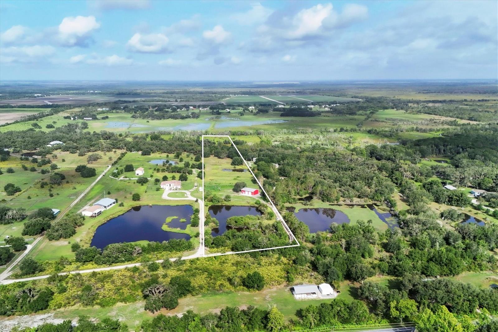 No HOA restrictions! Check out these 10 buildable, secluded, and partially cleared acres with breathtaking views and two ponds, perfect for building a home, farming, fishing, HORSES! and more. With all utilities including high speed internet you could park you RV on the land while building the home of your dreams! The property includes an existing 1,500sf metal 4 car garage / warehouse with two 10' bay doors perfect for boats, trailers, farm equipment, you name it. 400sf of the warehouse was recently converted to air conditioned office/flex space with a full bathroom. It has electric, water, high speed internet, and connected to septic. Fully insulated on all 4 sides (including the ceiling) and has full size washer & dryer hookups. There's still plenty of storage above the office space in the warehouse. Remaining warehouse / workshop space approximately 1100sf+/-. High and dry, flood insurance not required, although some parts in the back do stay wet during heavy rains in the summer. The pastures are perfect for a mini farm and are fenced & cross fenced, with the last pasture by the creek remaining unfenced. There's an area in the back with beautiful oak trees that would make the perfect secluded homesite. Per the previous owner one of the two custom ponds is dug to 32' for good drainage and to keep the water cool for healthy fish while providing a place for storm season run off. This larger front pond is spring fed and stocked with bass and blue gill. The other smaller pond is a livestock pond. Wild birds visit daily including bluebirds during their annual migration, as well as wild turkeys, deer, and monarch butterflies. Duette Nature Preserve and riding trails is less than 1 mile from the property and can be directly accessed via Logue Rd. At over 21,000 acres, the Duette Nature Preserve is the largest preserve in Manatee County with a wide variety of game, non-game animals, and native plant communities. It contains the headwaters of Manatee River. 3045 Logue Rd is a terrific piece of property located away from city life but close enough to Lakewood Ranch and Sarasota's excellent shopping, restaurants, golf courses, and entertainment. Request your private showing of this 10 acre piece of paradise today! Subsurface rights included. Also available for LEASE @$3,000/mo