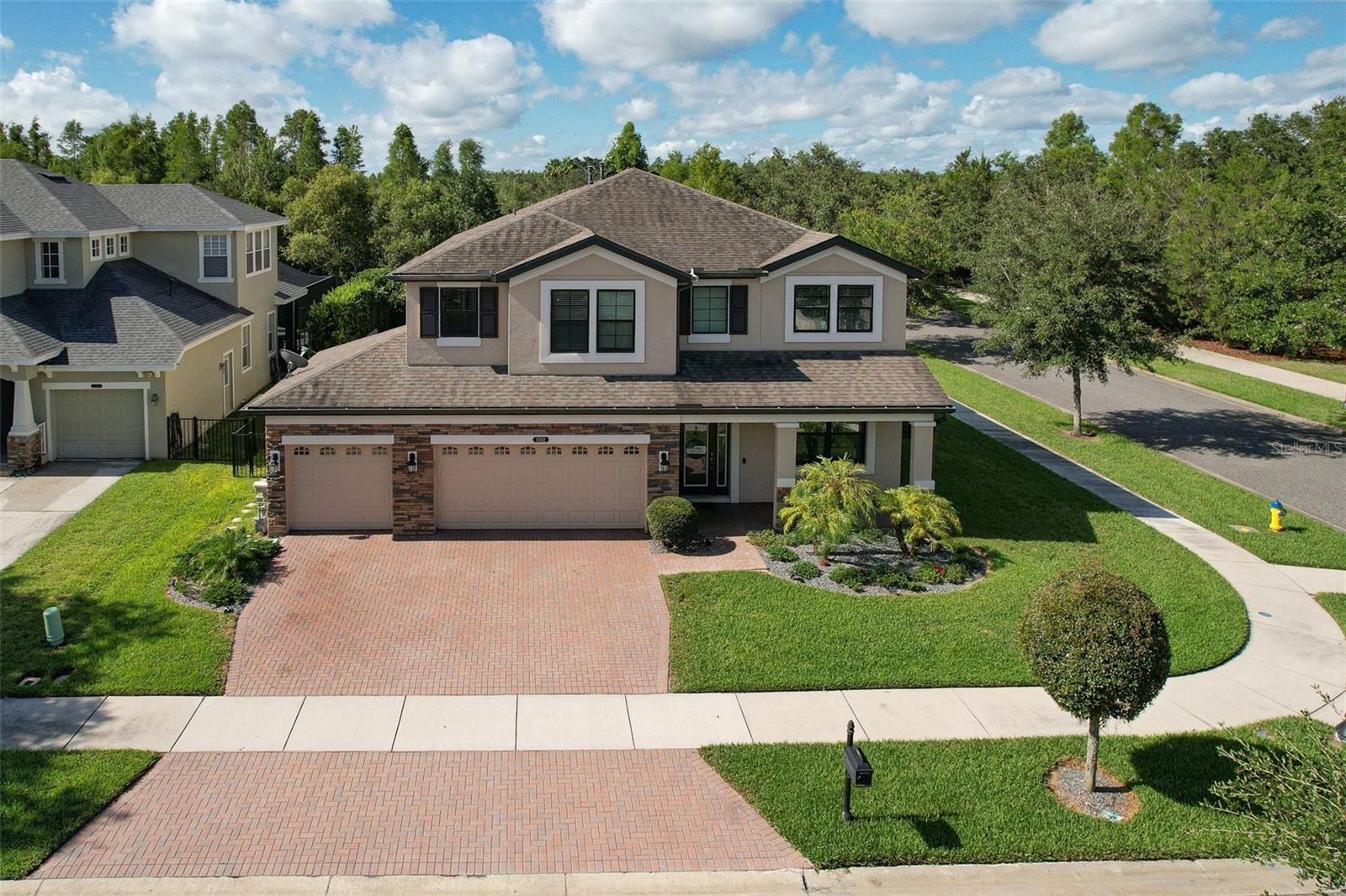 Welcome to this stunning 5-bedroom, 3-bathroom home built by M/I Homes, situated on a premium corner lot in the award-winning master-planned community of Connerton. Offering a rare 4-car tandem garage and a spacious 3-car wide driveway, this home combines thoughtful design, luxurious upgrades, and a true resort-style lifestyle. From the moment you arrive, you’ll notice the stacked stone elevation, covered front porch, rain gutters, and pavered driveway, setting the tone for what awaits inside. The main living areas on the first floor feature beautiful diagonal tile flooring, crown molding, and an open-concept layout perfect for entertaining. The gourmet kitchen is a chef’s dream, boasting quartz countertops, 42-inch upper cabinets with crown and over-cabinet lighting, stainless steel appliances including a built-in double oven and separate cooktop, a stylish backsplash, pendant lighting, and both a large walk-in pantry and a convenient butler’s pantry. The spacious family room flows into the dinette area with sliding glass doors that open to the show-stopping outdoor living space. Enjoy your own private oasis with a heated pool and spa, brick paver lanai deck, large covered area with two ceiling fans, a built-in BBQ grill complete with granite bar top and mini-fridge, and a screen enclosure that overlooks the peaceful conservation. The fully fenced backyard provides both privacy and space for relaxation and play. A mounted TV on the patio will remain, making this the perfect spot for game day or movie night. Downstairs, you’ll also find a guest bedroom with carpeted flooring and a full bath that includes a step-in glass shower and direct access to the lanai—ideal for pool guests or in-laws. A convenient under-stair storage closet and a laundry room with built-in cabinetry and a utility sink add practical function to the elegant design. Upstairs, the dramatic two-story foyer opens to a large bonus room with spindle railings overlooking the entryway. The luxurious owner’s suite features French doors, a tray ceiling, triple windows with views of the pool and conservation area, and an incredible 12x14 walk-in closet. The en suite bathroom offers dual vanities, a garden soaking tub, a separate glass-enclosed shower with listello accents, and a private water closet. The split-bedroom floor plan ensures privacy for all, with three generously sized secondary bedrooms—two with walk-in closets—and a guest bath with dual sinks and an additional linen closet in the hallway. Additional highlights include surround sound throughout the entire home (including bedrooms), a water softener, tankless water heater, granite countertops in all bathrooms, and ceiling fans throughout. With tile in all main living areas and wet spaces, the home is as low-maintenance as it is stylish. Living in Connerton means enjoying a vibrant, amenity-rich lifestyle. The community features a 10,000SF clubhouse with café, a lagoon-style pool with waterslide and splash zone, a heated Olympic-style lap pool, state-of-the-art fitness center, tennis and basketball courts, a sand volleyball court, multiple playgrounds and dog parks, and miles of walking and biking trails. You're also just steps from a neighborhood green space, gazebo, and additional playground, located right down the street from this incredible property.
This is a truly rare opportunity to own a meticulously maintained home with every upgrade you could ask for, in a community that offers the best of Florida living!