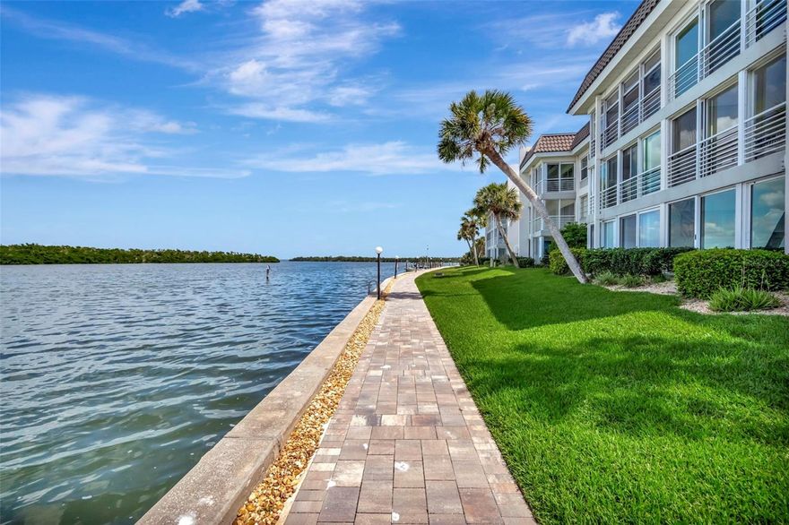 Recently reduced—don’t miss this opportunity. No special assessments after the 2024 storms, no history of flooding, well-funded reserves, and structural soundness supported by SIRS report! Exceptional value for a Longboat Key condo with private beach access. Enjoy deeded Gulf access with a residents-only community beach house featuring bathrooms, indoor/outdoor showers, seating, cabana space, and parking—your personal gateway to Gulf Coast living. Experience exceptional bayfront living at 4310 Falmouth Drive, Unit 102, located in the sought-after Longboat Harbour community on Longboat Key—a premier coastal city and barrier island along Florida’s Gulf Coast, renowned for attracting year-round residents, second-home owners, seasonal residents, and visitors seeking a refined, upscale seaside lifestyle. This A-Building, direct bayfront residence captures full Sarasota Bay views from the kitchen, dining area, living room, enclosed lanai, and primary bedroom—offering a front-row seat to sunrise skies, passing boats, dolphins, manatees, eagles and all kinds of exciting wildlife just 40 feet from the tranquil water vistas. Thoughtfully updated, the home features luxury vinyl flooring, upscale LG quartz Viatera Rococo countertops in the kitchen and both bathrooms, and soft-close drawers and custom cabinetry throughout. The spacious primary suite includes double vanities and a beautifully updated walk-in shower, while the guest bath also offers a walk-in shower with quartz finishes. Significant capital improvements provide peace of mind, including new hurricane-rated windows and sliders (2024, Cat5), HVAC (2021) with approximately 8 years remaining on a 12-year warranty, and a water heater (2023). The enclosed lanai expands usable living space while maintaining sweeping Sarasota Bay views. Offered fully furnished for a seamless, move-in-ready bayfront lifestyle. Longboat Harbour is a gated, resort-style community offering an impressive array of amenities, including four heated pools, tennis and pickleball courts with active player groups, fitness center, sauna, meeting rooms, billiards, putting green, woodworking shop, kayak storage, shuffleboard, locker rooms, fishing piers, two community grills, on-site management, and a protected harbor. Boat slips are available to members of the Longboat Harbour Yacht Club (subject to availability). Enjoy the best of island living with private deeded beach access just a short walk or drive across the street—complete with seating, chair storage, cabana, restrooms, indoor and outdoor showers, parking, and a convenient car-wash area. Additional features in the condo include washer and dryer connections in a hall closet and assigned covered carport parking with abundant guest spaces nearby. In the living room, open the sliders to seamlessly expand your indoor–outdoor living space, or keep them closed and enjoy the patio as an enclosed lanai—then open the glass sliders to let in refreshing coastal breezes and salt air. Located just 7.5 miles north of St. Armands Circle, and a short drive to downtown Sarasota’s Arts District, world-class dining and shopping, with Sarasota-Bradenton International Airport nearby. Direct Sarasota Bay views and private deeded Gulf beach access make this exceptional residence the ultimate Longboat Key lifestyle opportunity.