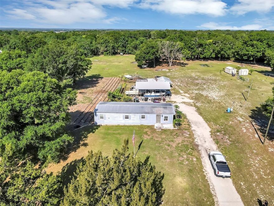 Welcome to your idyllic county retreat, nestled on 4.28 acres. This charming residence offers the perfect blend of comfort, functionality, and natural beauty. The spacious 3-bedroom double-wide home, renovated from top to bottom, features luxury laminate throughout, granite countertops, new windows and doors, and a new 5-ton AC. The expansive concrete pad with railing is ideal for entertaining and relaxation. Additionally, a new 30x35 metal-covered parking area accommodates your RV or boat, and a block building features a garage and a spacious shed for your tools. Zoned Agricultural, this property offers endless possibilities, located just a few miles from downtown Mt. Dora and 20 minutes from Orlando. Whether you're seeking to cultivate a homestead, enjoy a peaceful rural lifestyle, or create your own private haven, this property is yours. Schedule your appointment today to own this countryside paradise.