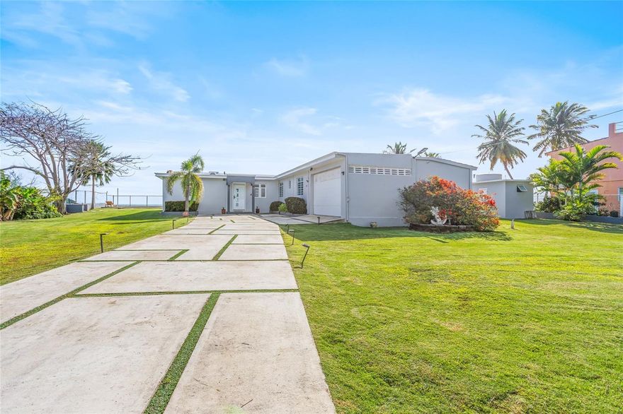 Located along the pristine shoreline of Camino Las Picuas, 14-2 Camino Las Picuas is a rare oceanfront sanctuary in one of Río Grande’s most coveted coastal enclaves — just minutes from Wyndham Grand Rio Mar and its world-class amenities. Set on approximately 2,600 square meters, the largest lot on the street, this three-bedroom, three-bathroom residence embodies the true spirit of a Puerto Rico beach house: spacious, relaxed, and intimately connected to the Atlantic.

Fully updated for modern coastal living, the home blends comfort with thoughtful design. The remodeled kitchen features contemporary finishes and a layout ideal for weekend entertaining, while new AC units throughout ensure climate-controlled comfort even in the island heat. A newer generator provides peace of mind for uninterrupted enjoyment, and a new retaining wall reinforces the property’s impressive landscaped grounds.

A thoughtfully designed split floor plan enhances privacy. The expansive primary suite is positioned at the front of the home, intentionally separated from the secondary bedrooms to create a true retreat within the layout.

The second bedroom features its own en suite bath, creating a comfortable and private setting for guests. The third bedroom — currently designed as an idyllic bunk room — embodies the spirit of a classic beach retreat, ideal for extended family stays and memorable weekends by the water.

Outdoors, the property truly shines. A beautiful terrace overlooks a private pool and an expansive stretch of landscaped green space rarely found in oceanfront homes, while direct beach access allows effortless transition from pool to sand to sea. Additionally, the property includes a fully equipped separate kitchen, designed to function independently from the main house — ideal for staff or supplemental food preparation during gatherings.

Designed as a family weekend retreat, 14-2 Camino Las Picuas has also proven successful as a short-term rental when not in use, offering flexibility without sacrificing the lifestyle experience. Every detail — from the scale of the lot to the thoughtful interior updates, outdoor living areas, and coastal orientation — reinforces the home’s lasting appeal.
Oceanfront location. Private pool. Fully updated amenities. Split-floor plan privacy. Guest-ready design. Direct beach access. Landscaped terraces. Separate service kitchen.

A property defined by proportion, position, and the enduring rhythm of life by the Atlantic — ready for weekends of family enjoyment, entertaining, and making lasting memories.