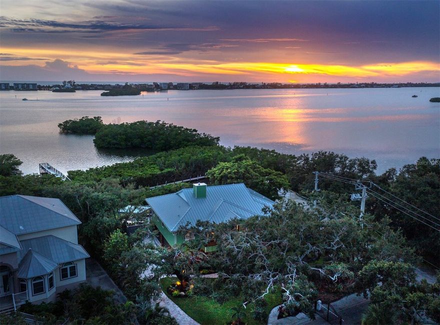 Welcome to your own coastal paradise—an exceptional waterfront home located in the exclusive, gated community of Fishermen's Bay, where every day feels like a vacation. Nestled directly on the Bayfront with breathtaking sunset views, this stunning property offers over 3,000 square feet of elevated living, plus a 1,300+ sq ft finished lower level, a 5-car garage, and dedicated Florida storage—ideal for kayaks, paddleboards, fishing gear, or your toys with wheels! Step inside and feel the difference: soaring 10' ceilings, elegant crown molding, and six sliding glass doors that flood the home with natural light and open up to panoramic water views from almost every room. The split floor plan offers the perfect balance of privacy and space, while the updated kitchen—featuring modern appliances—flows seamlessly into a cozy family room with a fireplace, ideal for entertaining after a day on the water. The master suite is a private oasis, with serene bay views that greet you each morning and a spa-like bath that invites relaxation. Guests will enjoy their own updated, private baths, making this home perfect for hosting family and friends. But the real magic begins outdoors. Walk out from the finished lower level to your private heated pool and spa, just steps from your personal dock—ready for boating, fishing, or simply enjoying the marine life that makes this area so special. Whether you're paddle boarding at sunrise, fishing off the dock at dusk, or sipping a cocktail while manatees pass by, this home is designed for a life well-lived. Fishermen's Bay is an intimate enclave of just 21 executive homes and lots, offering exclusive amenities including a private boat dock, scenic boardwalk, and unforgettable sunset vantage points. Enjoy direct access to the Gulf via the Intracoastal Waterway—no bridges—and unbeatable proximity to area beaches, fine dining, boutique shopping, cultural attractions, and the Pine View School. With recent updates including: NEW ROOF, NEW HARDIE PLANK SIDING, FASCIA, AND GUTTERS, NEW PAVER DRIVEWAY, NEW LANDSCAPING AND LANDSCAPE LIGHTING, NEW TREX DECK, NEW HARDWOOD FLOORS, NEW GARAGE DOORS, AND MORE - this home is move-in ready and waiting for your next adventure. Whether you're into boating, birdwatching, swimming, tinkering with your cars, or simply relaxing by the water—this is the Florida lifestyle at its finest.
