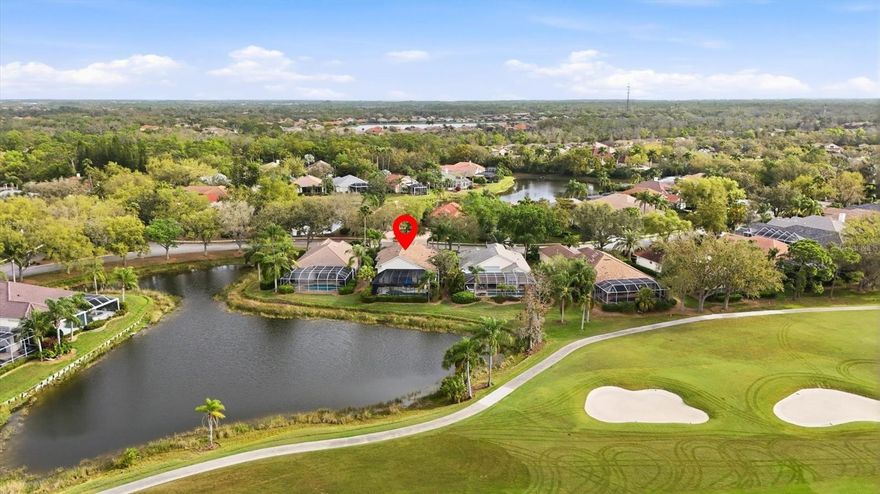 Tucked within the prestigious gates of University Park Country Club, this exceptional residence captures the rare beauty of both worlds—sweeping golf course vistas and tranquil lakefront views. Surrounded by lush tropical landscaping, the home offers a private oasis of serenity, elegance, and refined Florida living.
Inside, a grand open-concept floor plan features soaring ceilings and expansive, light-filled spaces. Walls of disappearing glass sliders open to the lanai, seamlessly blending indoor and outdoor living while showcasing breathtaking views. The elegant living and dining areas highlight a custom entertainment display and beautifully detailed windows with built-in bench seating.
At the heart of the home, the beautifully appointed kitchen blends style and function with waterfall-edge quartz countertops, custom cabinetry, premium finishes, and a large center island with casual seating. The thoughtful layout offers generous workspace and storage while flowing effortlessly into the dining and living areas—perfect for everyday living and entertaining.
The private office provides both sophistication and practicality with custom built-in shelving, a dedicated workspace, and a convenient wet bar—ideal for working from home.
Outdoor living truly shines on the expansive screened lanai, featuring a sparkling pool and spa and a fully equipped summer kitchen—perfect for entertaining while enjoying peaceful lake and golf course views.
Guests will appreciate the private guest bedroom and bath, while the owner’s suite offers a serene retreat with a beautiful bay window, private lanai access, and a spacious en-suite bath with dual vanities, garden tub, walk-in shower, and customized walk-in closet.
Located in University Park Country Club, an award-winning, resident-owned community, residents enjoy 27 holes of championship golf, Har-Tru tennis courts, pickleball, fitness center, croquet, and miles of tree-lined streets. Just minutes from downtown Sarasota, world-class beaches, fine dining, and cultural attractions, this home offers the ultimate Florida lifestyle in one of Sarasota’s most sought-after communities.