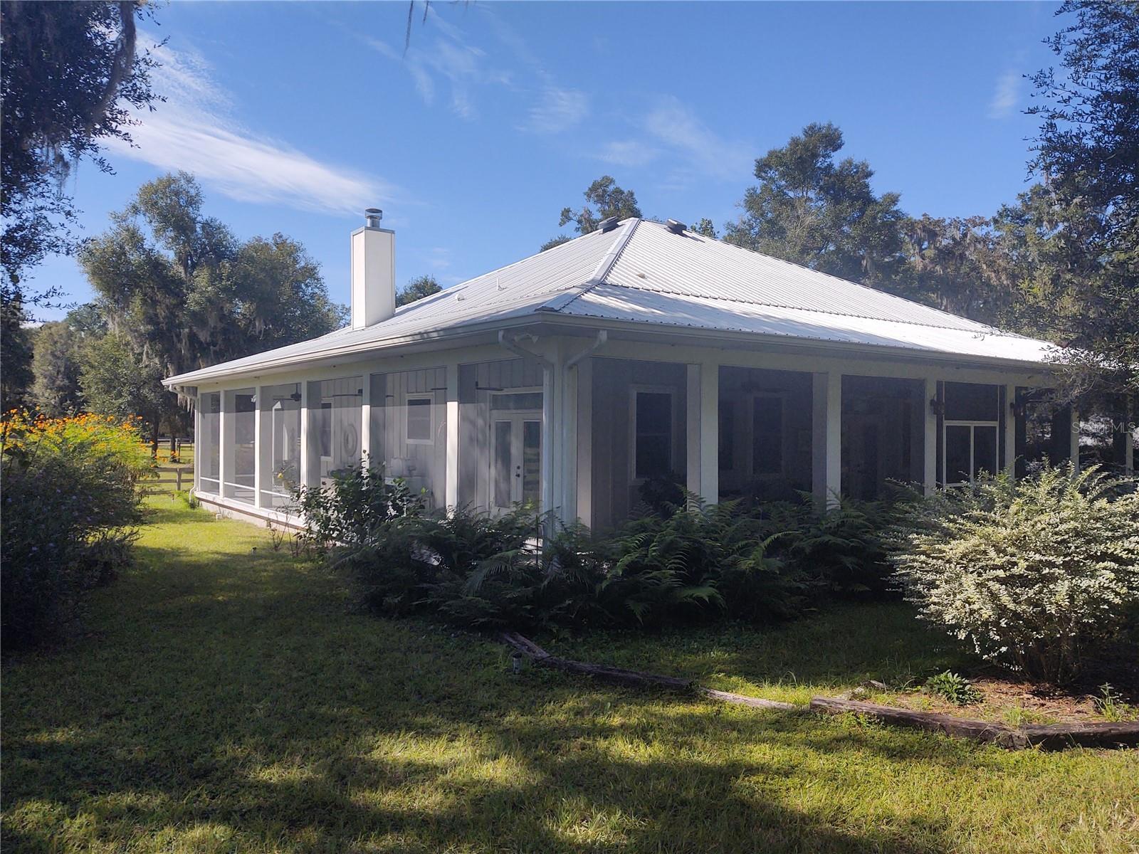 Designed after the DOGTROT style homes from the 1800's for functional design. Prior to air conditioning or electricity these homes were designed in warm climates to provide a cross breeze, brilliant architectural style. This is a modern replica in design of this style, with all the up to date amenities which results in low utility bills. Built in 2015 on a concrete slab reinforced with concrete exterior supports this home is here to stay, which also results in low insurance cost. There are French doors in every room which open out to the screened in wrap around porch, providing indoor/outdoor living. The eaves extend far out over the house protecting from sun and exposure to the elements. The actual roof covered footprint of the house is 3781 square feet, the heated square feet is 1875, leaving the porch at 1906. The metal roof is double insulated and painted with a reflective paint to ward against heat. Every step has been thoughtfully planned to comfortable living, pictures don't do it justice!! It is not actually certified , however, this house and footprint really falls into the PASSIVE house category. Located six miles to World Equestrian Center and nine miles to HITS, perfect location for the equestrian showing or conveniently located near multiple trailheads for pleasure riding.