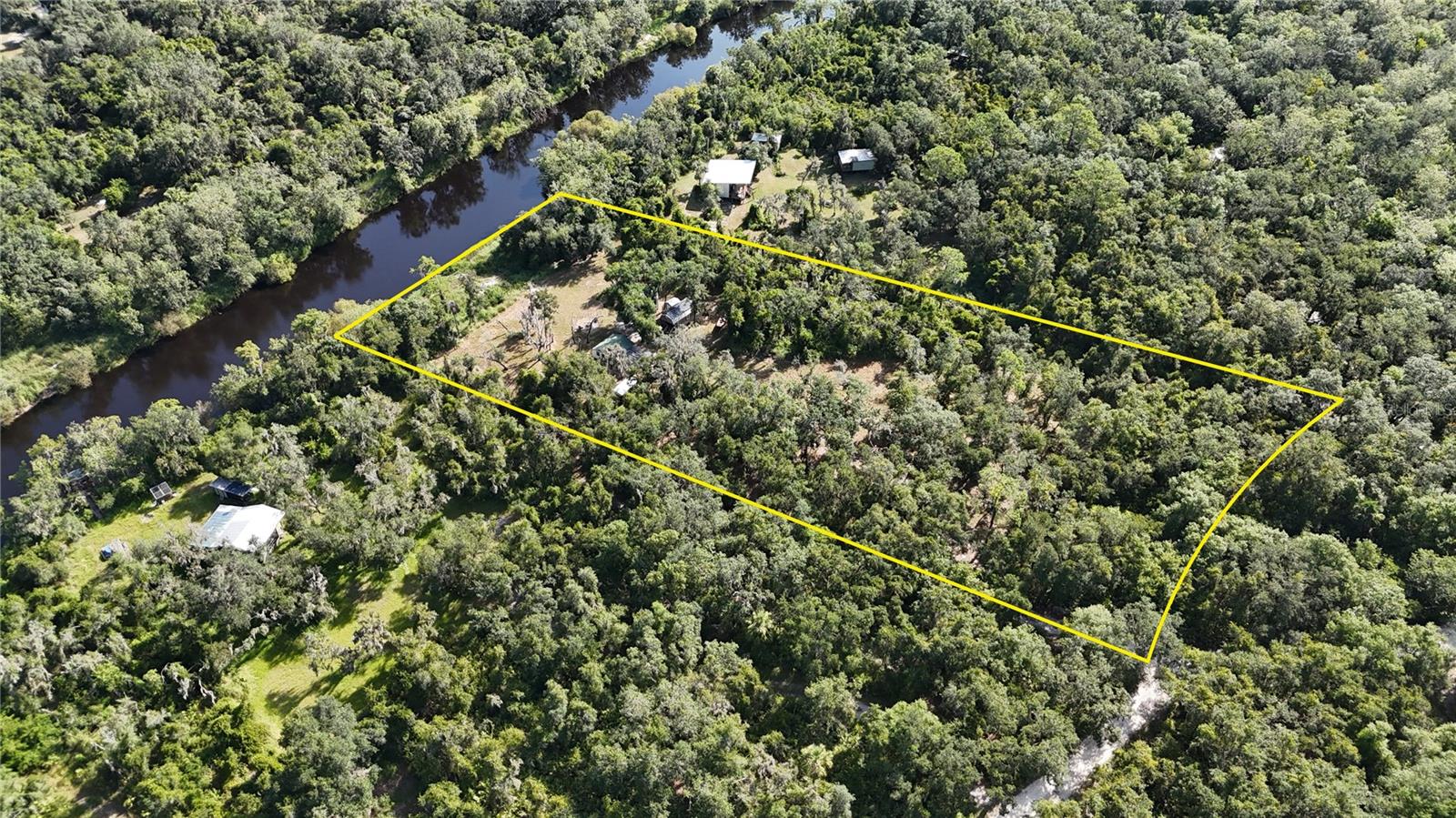 Welcome to your private riverfront sanctuary on the iconic Peace River in beautiful Arcadia, Florida, where nature, comfort, and adventure meet. And here’s an exciting part: SELLER FINANCING AVAILABLE! This breathtaking property spans over 2.5 acres of pristine Florida beauty, offering direct access to the river, perfect for swimming, kayaking, paddleboarding, camping, and more, one of the region’s best-kept secrets. Whether you envision a peaceful weekend retreat, an off-grid homestead, or a one-of-a-kind Airbnb investment, this property delivers unmatched potential. Tucked away behind a gated entrance and surrounded by mature oak and cypress trees, you’ll discover five thoughtfully placed structures blending charm and functionality: A charming cabin as the main structure, fully furnished, with air conditioning and rustic finishes. There is also cozy, insulated tiny home, and an equipped kitchen house, a separate bathhouse, and a secure shipping container for all your storage needs. Completely off-grid and self-sufficient, the property features a powerful and expandable 9.5 kW solar panel system that runs everything you need, and a flowing artesian well providing your own source of fresh water, say goodbye to utility bills! You’ll also find a riding lawn mower and mini bikes included, so you can enjoy and maintain the grounds with ease. The land offers wide-open spaces for gatherings, shaded picnic areas beneath the trees, and hand-built river steps that lead you straight into the water. Currently configured as 2 bedrooms and 1 bathroom, it’s move in ready or easily adaptable to your vision. Beyond the gates, you’re just minutes from Arcadia’s charming downtown, known for its antique shops, quaint cafés, and local boutiques. You can enjoy dining at cozy, family-owned restaurants, savor fresh Florida seafood, or explore unique eateries perfect for a night out. Nearby shopping centers provide convenient access to groceries and everyday needs, while local farmers’ markets offer fresh produce and homemade goods. Arcadia is also home to community events, art fairs, and live music, giving you the perfect blend of quiet country living and small-town charm. And with easy drives to surrounding areas, you’re never far from Florida’s Gulf Coast beaches or larger city amenities. Whether you’re looking to live sustainably, host retreats, entertain guests, or simply escape to the tranquility of nature, this property offers the freedom to do it all. Imagine waking up to the sound of birdsong, sipping your coffee on a rustic porch, and watching the river flow quietly in the background. This is more than real estate, it’s a lifestyle you’ll never want to leave, this property is vacant and ready for showings.