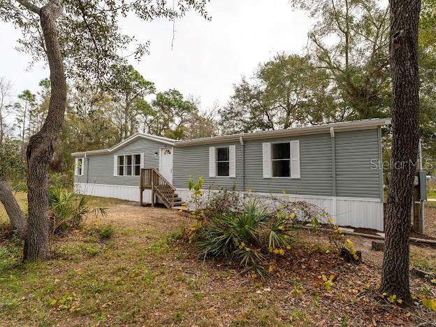 Newly Renovated 4/2 manufactured home on almost a half-acre and very private. Live near the city but feel like you are in the country. The home has a new fully remodeled kitchen with new stainless-steel appliances, solid wood cabinets with 32 in and 36 in top cabinetry for plenty of extra storage, soft close drawers with gold cabinet hardware adding a touch of elegance and luxury to the kitchen. Large family? Don't worry, this home is a 4-bedroom split plan home with two living areas. The living room and family room are large and spacious. The home has laminate flooring that looks like wood throughout and luxury vinyl flooring in the kitchen and both bathrooms. Nice size primary bedroom and master bath has a double vanity, a sunken tub as well as a large shower. Both bathrooms have been newly updated as well. All new lighting and ceiling fans throughout the home. New Rain Soft water filtration system. New hurricane impact front door. New roof installed 1/2025. HVAC system 2022 recently service with new thermostat installed 1/2025. This home is on well and septic, both in good working order. New pump for septic and new well pump 2022. The manufactured home has 2x6 wood exterior framing to improve energy efficiency and help reduce heating and cooling costs. Come and feel the freedom of 1/2 acre, picture having your family and friends over for a barbeque in the back yard. NO HOA fees! bring your boat, RV and toys. Moon Lake subdivision has a park with a playground and a free boat launch. Easy access to Suncoast parkway near the Ridge entrance to Tampa International Airport and surrounding area. Near shopping, restaurants and medical facilities.