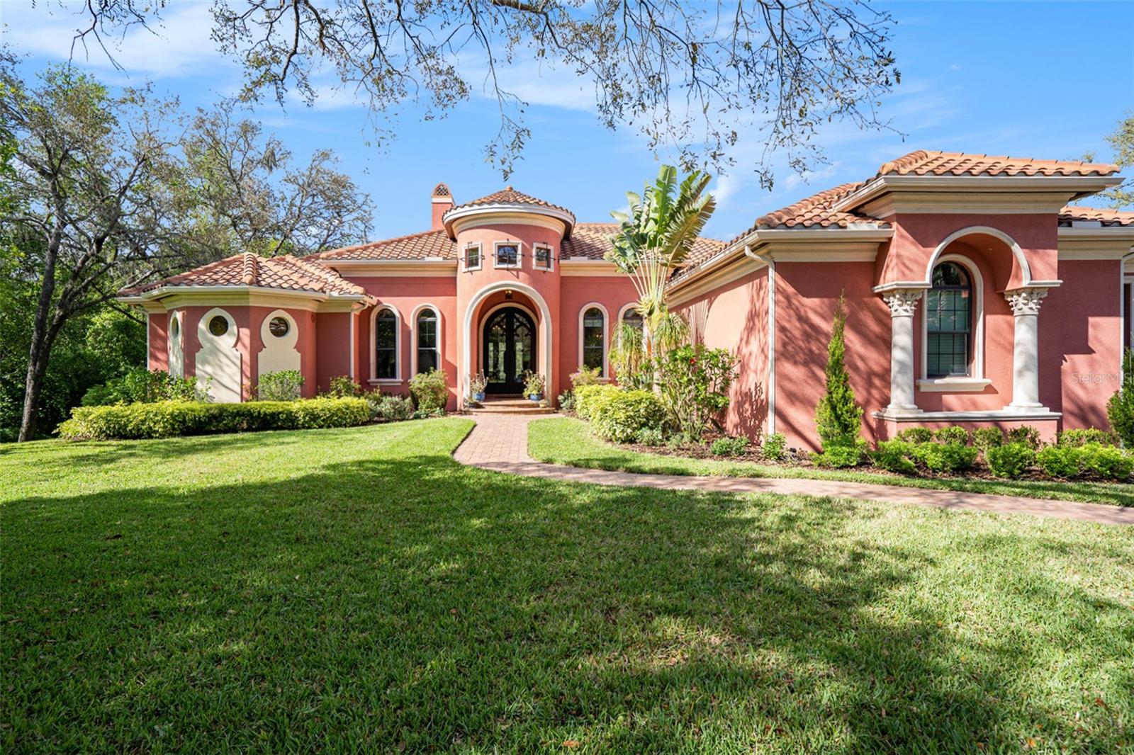 BACK ON THE MARKET -- Contract fell through! Inspired by Mediterranean villas, this home exudes luxury, comfort and elegance in the highly desirable, gated enclave of Tern Wood in FishHawk Ranch. Custom built by Homes by John C. Fowke, exquisite details must be seen to be appreciated. Nestled on a .75-acre lot, this stately home sits on a conservation lot with easy access to nature trails and shopping. A brick-paved driveway is surrounded by lush landscaping and an impressive turret shrouds the custom, iron doors that welcome you. Soaring ceilings grace the foyer and travertine flooring greets the eye as far as you can see. Step into the lavish living room with travertine columns and a fireplace with matching columns topped by beautifully carved lions. A formal dining room makes entertaining a breeze with its wet bar, fridge and plentiful storage. The adjoining kitchen is a gourmand’s dream, with an equally impressive travertine hood of unique design and a custom red LaCanche stove, made and imported from France exclusively for this house. Professional chefs would cherish the stove’s cast-iron traditional plate, the electric plancha and five gas burners. Enjoy the flexibility of an electric and gas oven, as well as a warming drawer to keep your food at the perfect temperature. The Sub-Zero refrigerator is beautifully integrated into kitchen by custom, furniture-grade wood panels. Storage is not a concern in the enormous walk-in pantry with onyx countertop and built-ins. The kitchen and family room are crowned by wood beams, and light bathes the large family room from expansive sliding glass doors on two sides. Escape to the lanai and immerse yourself into the surrounding woods. Relax in front of the masterfully carved fireplace or choose the gas firepit at the base of the heated pool’s infinity edge and spa. Customize the outdoor kitchen to your liking with the pre-plumbed water and gas hookups and exhaust vent. The gorgeous primary suite features a large bedroom with a tray ceiling and ample sitting room. The primary bathroom is understated elegance with soothing tones for maximum relaxation. The huge shower features a double entry on either side of the Jacuzzi tub, with space enough for two. Blue marble tops the counters' vanities, which feature furniture-style legs and make-up area. The water closet is complete with a bidet. Next to the bedroom, a wet bar with fridge makes trips to the kitchen unnecessary. Indulge in two large closets with built-ins -- you will never want to leave this sanctuary. Two other bedrooms feature a Jack-n-Jill bathroom and a fourth bedroom features an en-suite bathroom with a walk-in shower. The hallway has two closets to satisfy storage needs. The expansive bonus room has its own wet bar with fridge and enough room to watch the large TV or store exercise equipment. The huge laundry room features a farm-house sink, plenty of built-in cabinets and counter for folding laundry. A walk-in closet in the laundry room provides additional storage. Extra space abounds in the three-car, side-entry garage and brick-paved parking area. Maintaining the lawn is a cinch with irrigation from the well. FishHawk offers clubhouses, pools, tennis courts and more. In an A-rated school district, FishHawk is an hour away from Disney, Universal and Florida’s top beaches. Don’t miss the opportunity to own one of the most unique, special custom homes in the area. View https://listings.nextdoorphotos.com/16221terngladedrive/?mls
