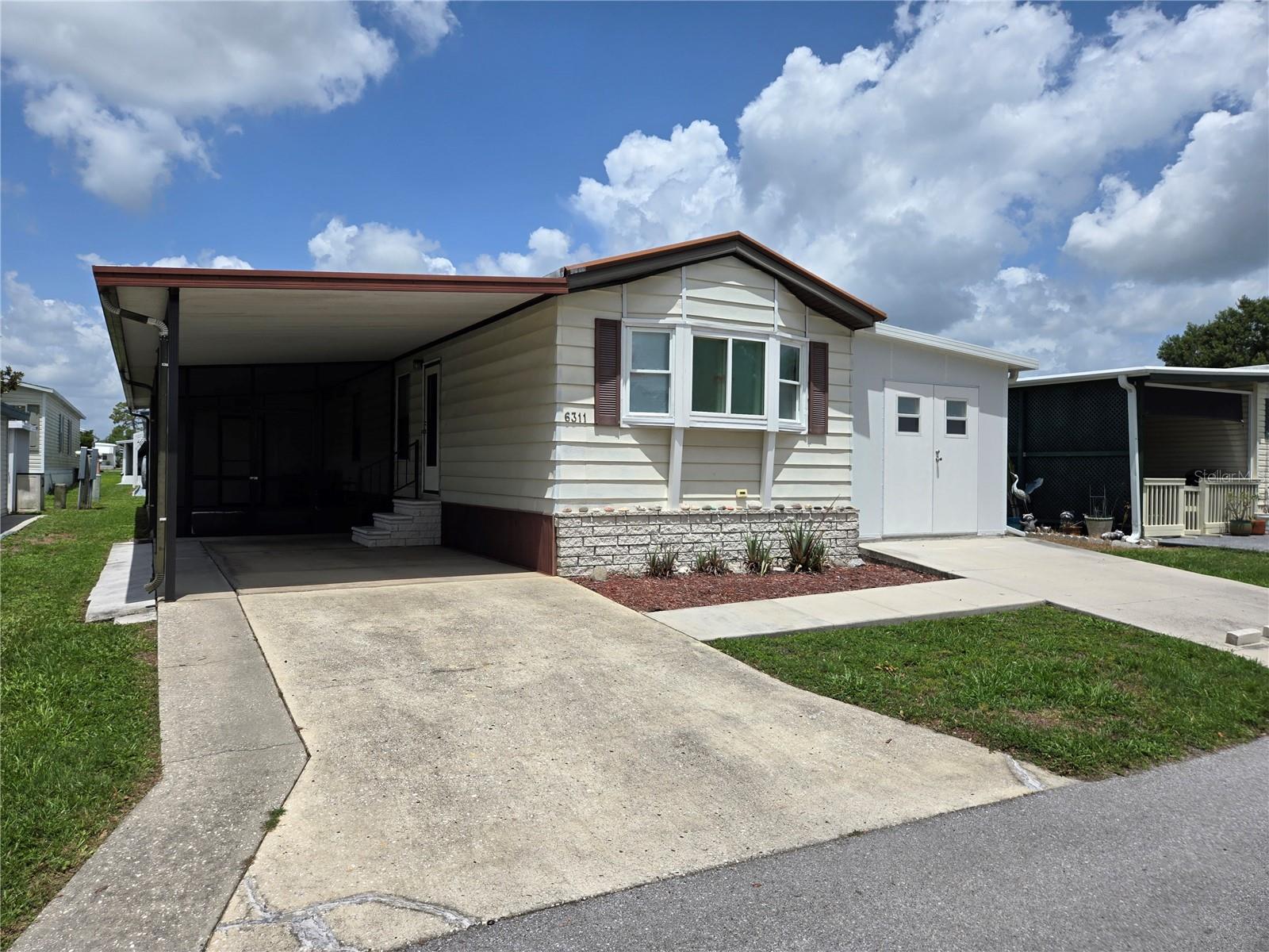 Welcome HOME to Country Aire Villages (55+). This is a co-operative Mobile Home Community with LOW ($130) monthly fees which include cable TV and internet also water, sewer, & trash. This Home has been beautifully remodeled with loads of up-grades. For a single wide, this is boasting with loads of space to spread out. Non Smoking owners and fully furnished. What more could you ask for? As you enter the property, you are welcomed by a beautiful outdoor sitting area under the carport and a spacious workshop. A perfect space for entertaining neighbors and friends. As you enter the home there is a beautiful updated kitchen with new cabinets and beautiful floors. Off the kitchen to the left is a perfect cozy living room. Enter the hallway and there is a second bedroom on your left with an adjoined full bathroom for guests. On the right of the hallway is a beautiful washer and dryer center just outside the Primary Bedroom. The Primary bedroom is spacious and has a full bathroom with walk-in shower. Off to the right of the hallway is a HUGE additional BONUS SPACE measuring a crazy 10' by 38' for your to add additional living space, work space or what ever you dream up. This Bonus Room was built to the Miami/Dade Hurricane standard. There is a double door entrance from the front of the house so you can park your golf cart inside. So much space at a great price. Enjoy the heated pool all winter and the crazy low HOA makes it affordable for snow birding or full time residence. Oh, You are traveling down in your R.V., No problem. You get a free parking spot in the 5 acres Lot for an R.V. or your boat. It does not get better than that.