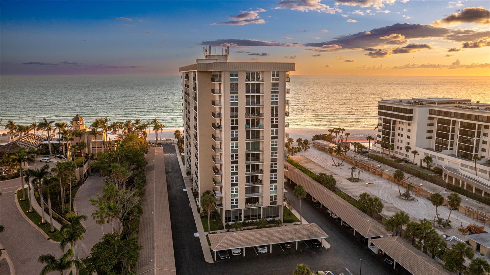 Experience breathtaking views in every direction from this expansive 9th-floor end-unit condo at Lido Beach Club, one of the largest two-bedroom floorplans in the building. With three private balconies, enjoy panoramic scenes of the Gulf, Sarasota Bay, and the city skyline, including stunning sunrises and sunsets. Just steps from the sand, this beachfront condo offers a rare combination of space, comfort, and location. Freshly painted and updated with new kitchen countertops, the open-concept layout features a spacious kitchen with a large island, ideal for casual dining or entertaining. The kitchen flows into a bright living and dining area, where a full-length mirrored wall enhances the sense of space while capturing the reflection of the bay and skyline beyond. Floor-to-ceiling hurricane-rated sliders and windows flood the unit with natural light and frame sweeping coastal views to the north and south. The split bedroom design ensures privacy, with each suite offering direct balcony access and its own full bath. The oversized primary suite includes a walk-in closet and a flexible sitting area, perfect for a reading nook, office, or lounge space with views of the Gulf and beyond. Lido Beach Club provides resort-style amenities, including direct beach access, a newly renovated beachfront pool area, fitness center, grilling station, and dedicated storage for bikes and beach gear. The association is professionally managed with proactive leadership and a strong sense of community. Located just minutes from St. Armands Circle, this residence offers easy access to fine dining, boutique shopping, and the natural beauty of South Lido Park and its kayak trails. **THIS PROPERTY QUALIFIES FOR A 1% LENDER INCENTIVE IF USING PREFERRED LENDER. INQUIRE FOR MORE DETAILS.**