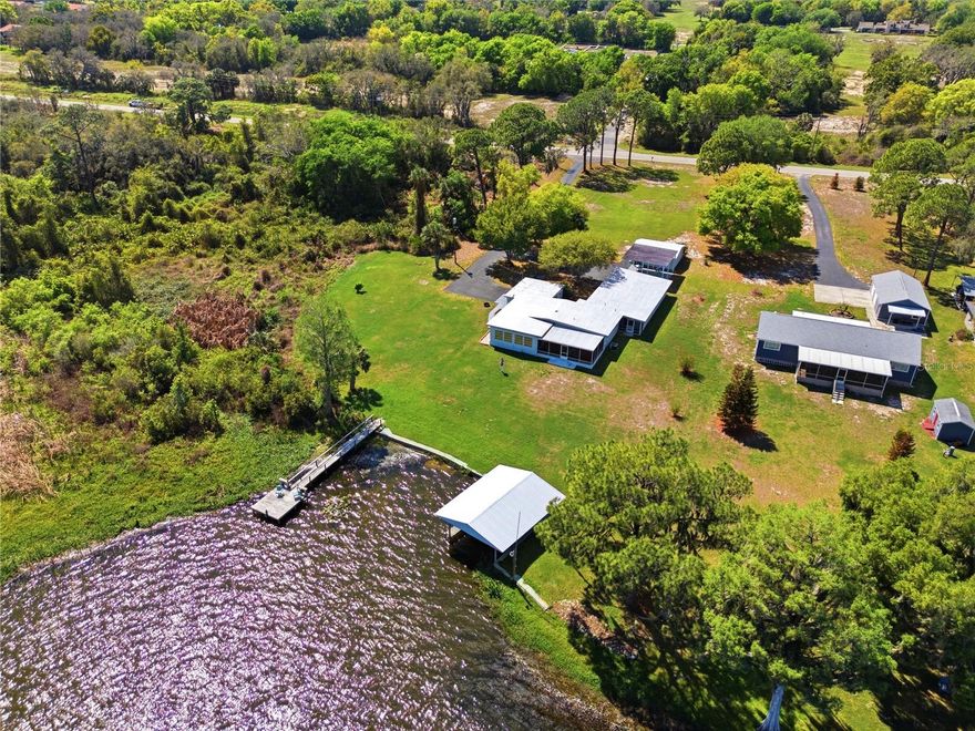 Dream of chasing trophy largemouth bass or filling the cooler with tasty speckled perch? Welcome to 8342 W Lake Marion where you'll experience the beauty of Florida lakefront living on the shores of Lake Marion, a pristine 3,000+ acre lake known for its natural shoreline, exceptional fishing, and abundant wildlife. Situated on just over 1 acre with no HOA, this updated and well kept home offers privacy, space, and a lifestyle centered around the water and nature. The home features over 2,000 sqft of living area and more than 3,200 sqft under roof, including garage, workshop, and covered parking—ideal for storing boats, equipment, and recreational vehicles. Inside, the home opens to wide, open living spaces filled with natural light and expansive lake views. The main living area showcases tile flooring and seamless flow into the kitchen and dining spaces, all designed to take full advantage of the waterfront setting. Large windows and glass doors frame the lake from nearly every angle, creating a constant connection to the outdoors. The beautiful kitchen is both functional and inviting, featuring granite countertops, custom wood cabinetry, stainless steel appliances, and a convenient pass-through to the dining area, making it ideal for both everyday living and entertaining. The primary suite is generously sized, with ample closet space and an en-suite bath with custom cabinetry, granite countertops and a walk-in shower. The guest bedroom and guest bathroom are both equally spacious and well-appointed. One of the standout features of the home is the expansive screened porch, providing a comfortable outdoor living space where you can relax, entertain, and take in sweeping views of the lake year-round. Step outside and fully embrace the waterfront lifestyle with a private dock and covered boathouse, making daily boating and fishing effortless. Lake Marion is widely known for trophy largemouth bass, speckled perch, bluegill, and catfish, while its natural shoreline attracts abundant birdlife, creating a peaceful and ever-changing backdrop. Additional features include a detached garage with workshop, multiple storage areas, and a large covered carport, offering flexibility for hobbies, storage, or outdoor equipment. What truly sets this property apart is its proximity to thousands of acres of protected land. Just minutes away, the Lake Marion Creek Wildlife Management Area spans over 8,000 acres of preserved Florida wilderness, offering trails for hiking, wildlife viewing, and exploration through pine flatwoods and oak hammocks. Nearby, the Bellini Preserve adds even more protected shoreline and native habitat, while Allen David Broussard Catfish Creek Preserve State Park and The Nature Conservancy's Disney Wilderness Preserve provide additional opportunities for hiking, birdwatching, and experiencing Florida’s natural ecosystems all under a 1 hour drive. Together, these conservation areas create a setting where nature isn’t just nearby—it’s part of your everyday life. Located near Haines City and Davenport yet tucked away in a peaceful, natural setting, this property offers the perfect balance of privacy and accessibility. Whether you're seeking a full-time residence, weekend retreat, or a place to truly connect with nature, this Lake Marion property represents a rare opportunity to own a piece of authentic Florida lakefront living.