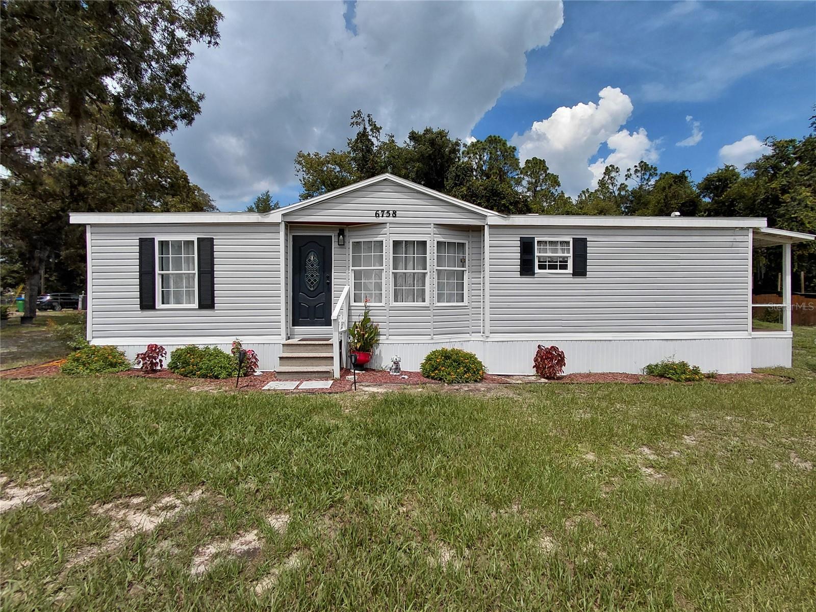 Welcome to this charming home set on a spacious, fully fenced and gated half-acre lot. With 1,180 square feet of living space, it offers 3 nice sized bedrooms with a walk-in closet in the master bedroom. 2 bathrooms, and a relaxing large open deck porch ideal for either relaxing or entertaining guests. The interior has been thoughtfully renovated, blending warmth and style with a seamless flow from room to room—creating a space that feels both open and inviting. 2 lots totaling a half-acre provides endless possibilities, whether you dream of a vibrant garden, an outdoor entertaining area, or simply room to spread out and enjoy this home is a must see! Conveniently located just minutes away from outdoor recreation and natural beauty, this move-in ready home combines comfort, space, and opportunity. All that’s missing is you! New Water softener - filtration system recently installed in late 2024 along with a new hot water heater. Electrical panel and wiring updated early 2025. New A/C installed in 2022. Storage Shed is also included.