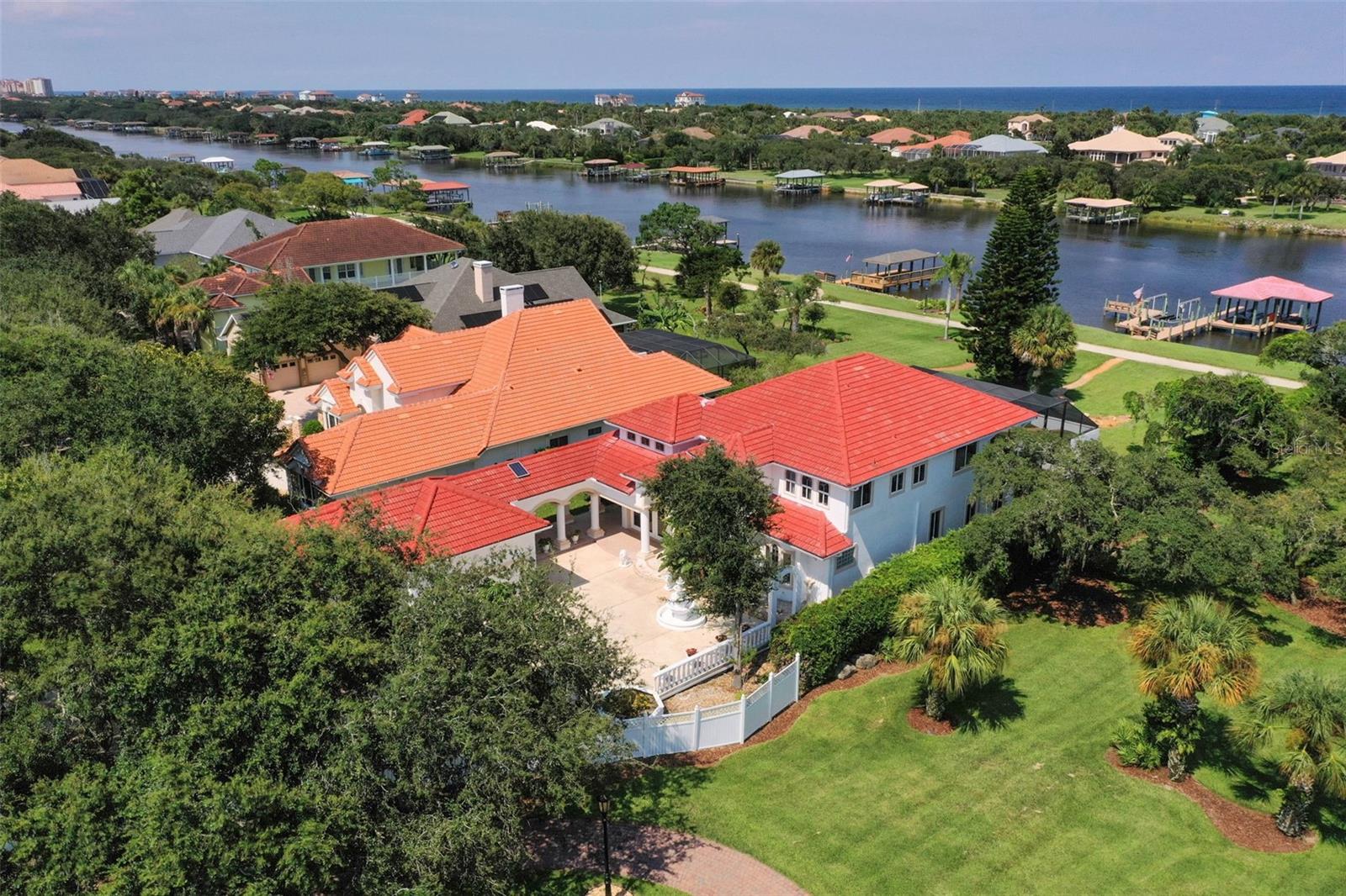 Tucked away in the prestigious gated community of Grand Haven, 63 Front Street offers a rare combination of elegance, comfort, and direct access to the Intracoastal Waterway. Situated on nearly three-quarters of an acre, this impressive estate features over 3,200 square feet of living space, blending Mediterranean-inspired architecture with timeless Florida coastal living.
With a classic barrel-tile roof and a stately façade, this custom-built residence makes an immediate impression. The property is beautifully landscaped with mature trees and lush greenery, providing privacy and a resort-like feel. A circular drive and detached two-car garage add convenience and curb appeal.
The backyard is a true oasis with expansive green space, vibrant palms, and direct access to the Intracoastal Waterway via a private dock with covered boat lift—perfect for boaters and water enthusiasts. From this vantage point, you can enjoy both sunrise and sunset skies, with the Atlantic Ocean just minutes away.
Designed for entertaining, the screened pool and spa area offers ample room to lounge, dine, and relax while taking in serene water views. The red tile-accented pool deck and dual fountains create a stylish retreat, while covered patio spaces flow seamlessly into the interior.
Inside, soaring ceilings and arched architectural details set a tone of sophistication. The grand foyer opens into spacious, light-filled living areas, where large windows frame views of the water and surrounding greenery. Hardwood floors, decorative niches, and elegant finishes add warmth and character throughout.
The chef’s kitchen is both stylish and functional, featuring granite countertops, an oversized island, double ovens, stainless steel appliances, and abundant cabinetry. A charming breakfast nook and adjacent family room make it the heart of the home.
The formal living and dining rooms provide additional space for entertaining, while cozy fireplaces enhance the ambiance.
With three bedrooms and three full bathrooms, the home offers comfort and privacy for family and guests. The primary suite is a retreat of its own, boasting a spa-like bathroom with marble floors, dual vanities, a soaking tub, a glass-enclosed walk-in shower, and elegant design touches like a crystal chandelier and column accents.
This home blends functionality with timeless style, offering the best of Florida living. Whether it’s mornings by the pool, evenings on the dock, or hosting friends in expansive living areas, 63 Front Street was built for both relaxation and celebration.
With its expansive lot, Intracoastal waterfront setting, resort-style amenities, and Grand Haven’s exclusive community lifestyle, this residence stands as one of Palm Coast’s most desirable opportunities.