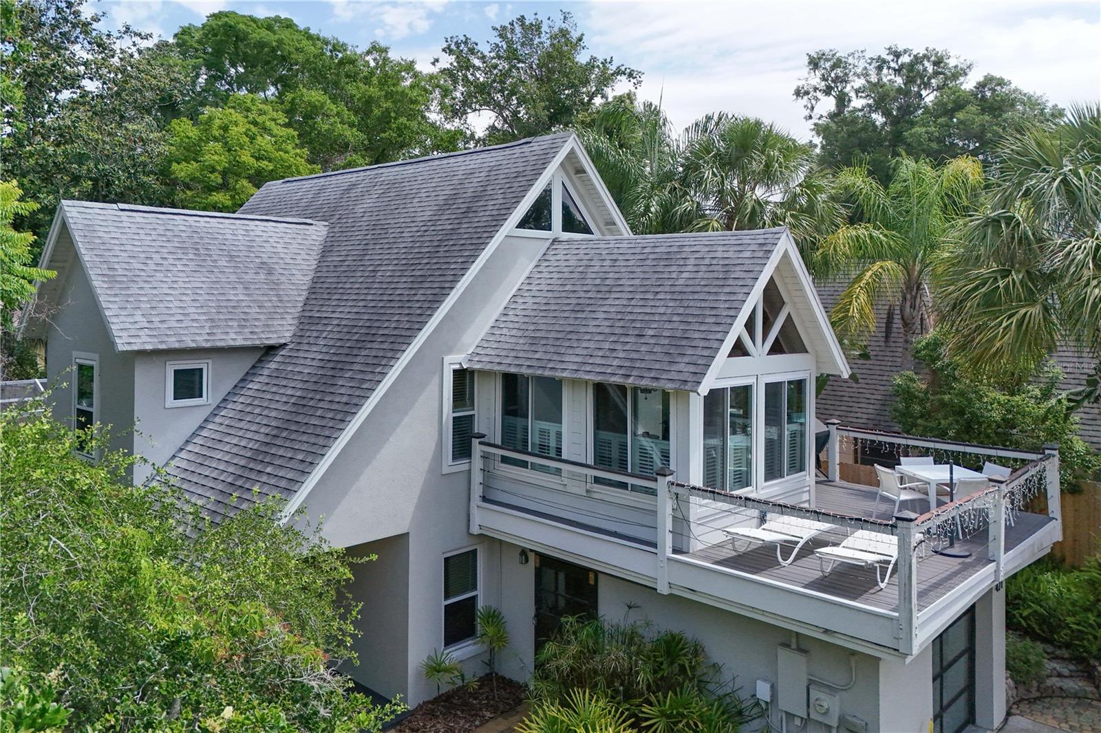 Discover this treasure on west 10th, near downtown Mount Dora. Lots of history and love went into creating this unique pool home, hidden in a very private setting. What started in 1948 as just a garage, the home evolved in the early 1990’s to be a unique custom-built primary home or a hide-a-way retreat second home or rental. What a find... and only a few blocks from downtown! The 2-story home with loft and a guest cottage has tree-top decking overlooking the gardens, with the pleasant sound of the fountain below. Your eye will be delighted by Custom-built cabinetry, shelving, wood floors, trim and ceilings & beams! Detailed craftsmanship & natural materials enhance the home's simple elegance. The unique floor plan offers a spacious primary suite with sky lights & special windows, plus a well-appointed study/den/guest room on the ground level. From the bedroom, step out to the patio and gardens with a path to the pool and a short path winds to the 1/1 guest cottage - a welcoming retreat for family or friends. The main house has 2 bedrooms and 2 full baths, plus a den & laundry room. On the home's second floor, there is a well-planned eat-in kitchen and a cozy 2nd bedroom & bathroom. Living & Dining rooms with vaulted ceilings open to a spacious deck brushed by gentle breezes. High above the living room, a LOFT sparks the imagination - perhaps a studio for art, yoga or music! Throughout the home, natural light pours in through wide windows; picturesque views abound. Most recent updates were: Roofs were replaced in 2017, HVAC in 2019. Also in 2015 windows were replaced with energy-efficient double pane, a tankless hot water system was added, Central AC replaced, & new garage door. . Quartz countertops grace the laundry room and the kitchen. Kitchen features include: Subway tile back splash and stainless steel appliances along with a cozy nook for kitchen dining. The main dining room is surrounded by windows - wood pitched ceiling and a glass French door leading out to the deck. The 1/1 guest house has tile floors, a mini-split AC system, a French door and a beautiful walk in shower that would make any guest want to stay. . Being just a few short blocks from downtown & Lake Dora, nearby are parks, lakeside walks and the many delights of historic downtown; walk to gallery openings, cafes and after-dinner concerts. You will love living in Mount Dora, known for its tree-lined streets and year around festivals on the shores of Lake Dora.