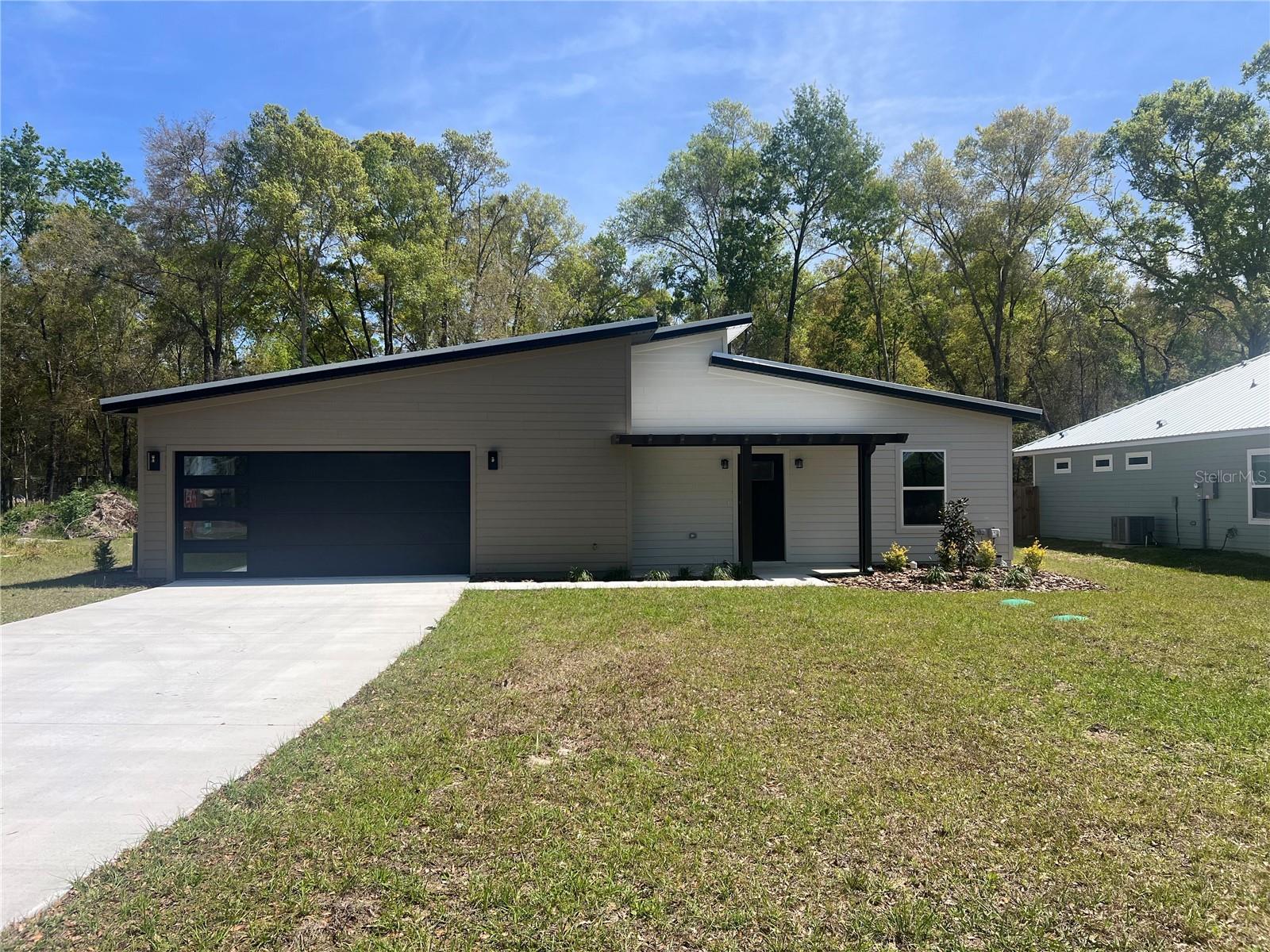 This 3/2 Contemporary style home is built by well know builder, Next Gen Custom Homes. This open floor plan flows seamlessly through the home. Primary bedroom is complete with a walk in closet, an en suite bathroom with double vanities and a walk in shower. Enjoy your coffee on the covered back porch gazing out onto this oversized lot. Located just over the Gilchrist county line, you will enjoy lower Property taxes while still having the convenience of a short commute to the Newberry and Gainesville area.