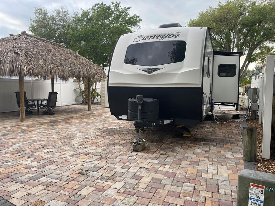 Situated minutes North of Tampa is a gated RV Park designed for people who prefer to enjoy the outdoors without clothes. Yes, this well-maintained Nudist community features a club house, laundry facility, indoor showers, and an outdoor pool. Low monthly dues include your cable, internet, water, sewer and garbage. When you purchase this RV lot you will get the deed to the land and a 2020 Forest River “Surveyor” travel trailer. The interior of the trailer looks barely used. The furniture that is in the trailer will be conveyed. The travel trailer has two exit doors in the living room and one in the bedroom. Stove has three burners, and a separate microwave. Island style sink. The unit has a TV in the living room and a fireplace. Bedroom also has a flat screen TV. The RV lot has a shed and a large Tiki Hut. The lot is primarily brick pavers with a large Bird of Paradise growing on the SW side of the lot. Less landscape to fuss over means more time for you. The Seller will consider selling financing with a ten-year mortgage. Paradise Pines is located next door to Lake Como and is also near other nudist resorts. Minutes from shopping malls, restaurants, public golf courses, 45 minutes to Gulf Beaches and about thirty to thirty-five minutes from Tampa International Airport.