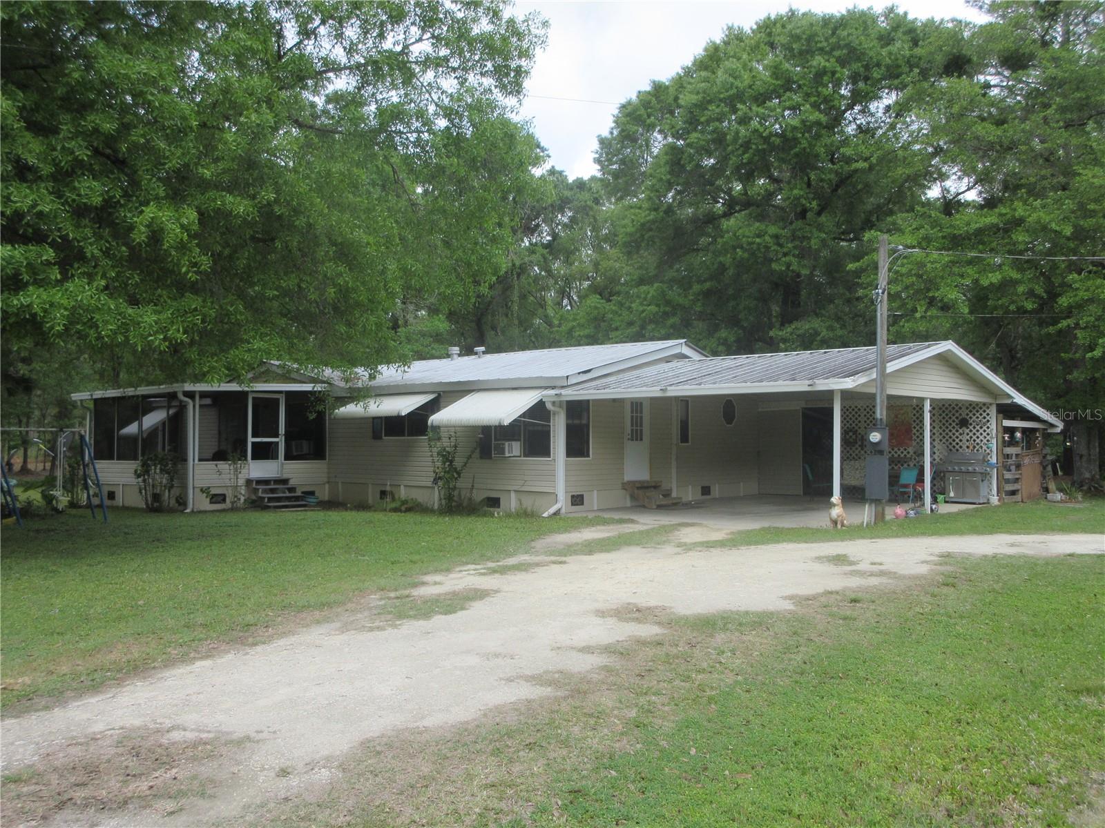 FREEDOM AT LAST AT AN AFFORDABLE PRICE! FHA financing available. Come see this gorgeous 5.54 acre mini-farm property zoned A-1 Agricultural with a spacious 3/2 1993 Double wide mobile home with 207 feet of paved road frontage. Is it in a flood zone? Most of it, yes. But let me tell you what it does have! NO HOA! No HOA FEES! The tenant says she has lived there for years and has never seen standing water on the property. Bring your horses, cows, dogs, cats and more! Outside features a 2 car carport, with large storage area, a breezy screen room, rear covered patio, shed, lean-to, two chicken coups and a hog pen! The home is nicely under skirted with cement board. The owner feels the metal roof is approximately 10 - 12 years old. There are seven window awnings for afternoon sun and lush pasture land on the front and gorgeous woods on the back filled with wild life galore! But most of all "QUIET AND PRIVACY". Why? Because there is a powerline easement on the north side giving you that permanent privacy. Inside features a large Great Room/Dining room combination with a cozy wood burning fireplace, a huge country kitchen with a lovely breakfast area, handy laundry area, polybutylene plumbing and a large master bedroom with twin closets. The master bath features a lovely free standing soaking bath tub with a beautiful octagon colored window above it. If buyer desires an FHA loan, the seller will have the required tie downs installed. The Ocala National Forest is located just a short distance away which affords you almost a half million more acres to roam in with 600 lakes, two rivers, hunting, gun range, ATV trails, multiple springs, boating, jet skiing, kayaking and some of the BEST BIG BASS FISHING anywhere. It's all yours at an affordable price of just $229,900 cash! A great property at a great price . A lot for your money this time! Let the fun begin, you need it! But hurry because it's what most people are looking and dreaming of. So let's make your dream come true for a change! It's a happy place where you are free to roam. No neighbors on 3 sides.