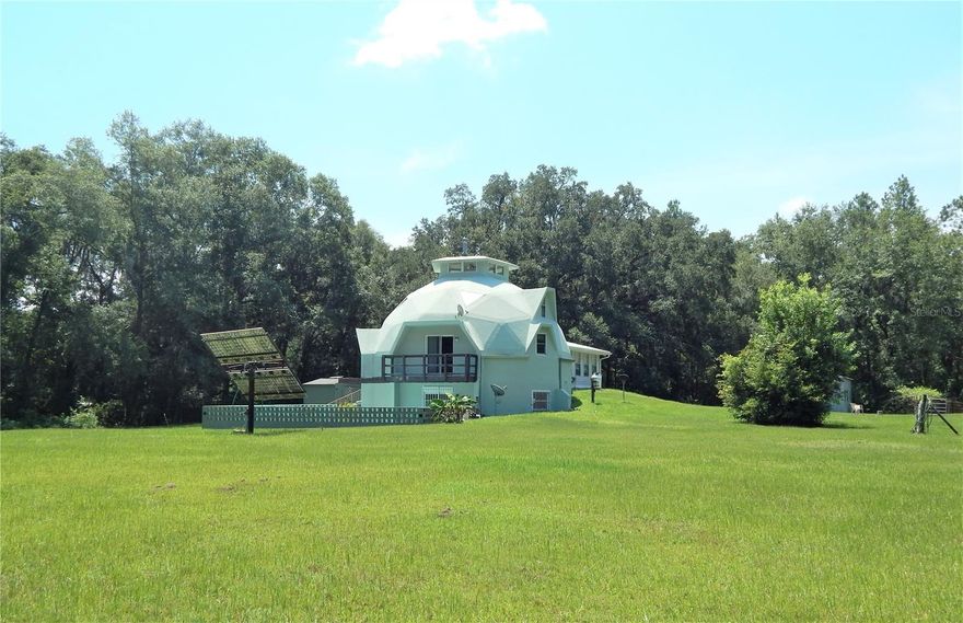Let's make a Deal on this Custom Built Geodesic Dome Home that sits on 5 Peaceful Acres offering Privacy & Space! The Home features 2 separate living areas that can become 1. 1st Level has 2Bdrms/1Bth with Full Kitchen and a Woodstove and the 2nd Level features 3Bdrms/2Bths with Full Kitchen and Loft. Plenty of Storage Everywhere! Also, there's a detached 30x30 A/C Rec. Room. Home is equipped with a Security System, Solar Power w/Converter, Gas Appliances and a Generac Whole House Generator! And Last but Not Least! A 9x28 Underground Bomb Shelter/Safe Room w/ Swiss Made NBC Air Purification System and Bunk Area! Property Features a 10x20 Inground Pool, 30x30 Metal Bldg w/ Overhead Door, Separate RV Hk-Up w/30 Amp Elec, Gas, Septic and Phone lines. Also, the Property has a Lg. Fenced Off Fish Pond, Shooting Range w/ Berm, Well w/Bk-Up Pump and Tank, and a Wood Garden Shed. This Energy Efficient Home has 12" Poured Concrete Construction and is Hurricane, Tornado and Fire Resistant! Also, you won't see any Termites Chewing on this House! NO Deed Restrictions! NO Flood Zone! 
Includes Solar Frost Refrigerator, 2 Solar Frost Freezers and a 5x8 Solar Tube Water Heater! Property is partially fenced.