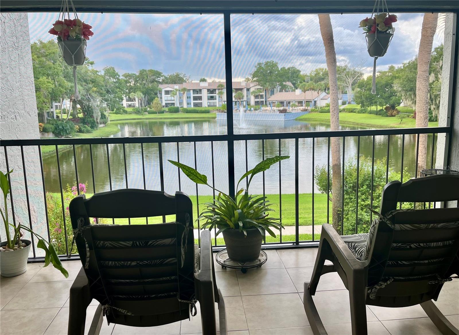 Charming spacious second floor unit welcomes you into a relaxing lifestyle, with all the amenities, shops, eateries and entertainment Altamonte Springs offers. Easy peasy access to I-4, 436,Altamonte Springs Mall, Crane's Roost Park, to name a few. 1,341 sq ft, open split level floorplan. The patio offers a serene view of the water fountain, pond and occasional visits of beautiful birds fluttering about. Wood burning fireplace and wet bar in the living room. Storage closet in the patio. Flooring in bedrooms and bathrooms is Milton Pointe, Milton Gray Woodplank Ceramic Tile.
Owner will pay the one time full assessment at closing. HOA of $600 monthly covers basic cable, internet, all exterior building improvements/repairs including the roof, road maintenance,clubhouse, pool