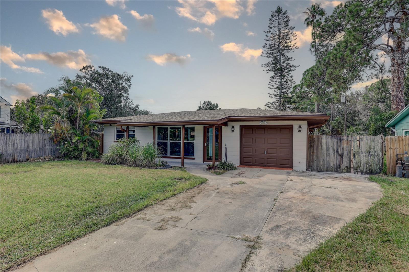 Beautifully updated 2BR/1.5BA block home with 1,183 sq. ft., perfect as a starter home, downsizing option, or Florida investment property. Featuring luxury vinyl flooring throughout, a light-filled open living room, and a modern kitchen with convection oven, microwave, dishwasher, and refrigerator—this home is move-in ready. Both bedrooms offer built-in closets, with a full bath and convenient half bath. Extras include a dedicated laundry room, central air/heat, slab foundation, and shingle roof. Outside, enjoy nearly 6,400 sq. ft. of yard space with an outdoor fireplace, 1-car garage, and room to garden, play, or even add a pool. With no HOA, you can move right in and start living the Florida lifestyle today!