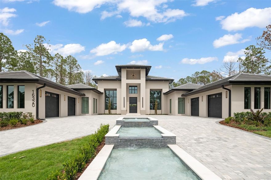 A bold expression of modern architecture...a newly completed custom estate in the guard-gated community of Bella Collina. Perfectly positioned on an elevated preserve lot, this striking residence features clean lines, dramatic symmetry, and a tiered water feature leading to an impressive entry.

Inside, over 6,400 square feet of designer-curated interiors present a seamless blend of minimalism and warmth. The main living space showcases soaring ceilings, expansive sliders, and a sleek chef’s kitchen with integrated appliances, custom cabinetry, and a concealed catering kitchen. A floor-to-ceiling wine wall accents the formal dining area, while the grand living room invites effortless indoor-outdoor living.

The serene primary suite overlooks a courtyard, separating the main home from the detached gym and guest quarters, and includes a spa-inspired bath with separate walk-in closets for him and her, each custom-designed with integrated lighting and modern finishes. Two guest bedrooms with ensuite baths, a media room, and a third guest suite which also functions beautifully as a flex space complete the interior layout.

Across the courtyard, private wellness and guest suite provides incredible flexibility with a full in-law suite including an ensuite bath, a private gym, a sauna with indoor shower, a full kitchen (no oven), and lounge space—all with direct access to the pool and a private outdoor shower.

Enjoy resort-level living with a summer kitchen, sunken firepit, and a show-stopping pool and spa complete with water features and a retractable movie screen.

Residents of Bella Collina enjoy exclusive access to a Sir Nick Faldo-designed golf course, a private lakefront clubhouse, two restaurants, luxury spa, fitness center, tennis, pickleball, and numerous social and culinary events. This one-of-a-kind estate combines sculptural architecture with lifestyle-driven design in one of Central Florida’s most coveted communities. The $40,000 Sports Membership Deposit is deferred from the developer