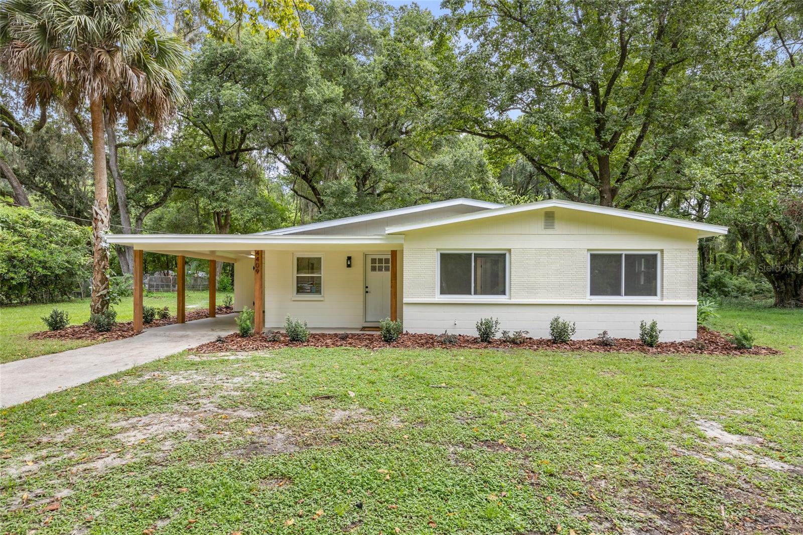 One or more photo(s) has been virtually staged. Welcome home to this charming turn-key 3 bedroom / 1 bathroom property in prime SW Gainesville location. This home has been completely renovated with a central HVAC system (only had window units), luxury vinyl plank flooring throughout, walls, baseboards, paint interior and exterior, lighting, interior and exterior doors plus hardware and so much more. Kitchen is showcased with quartz countertops, new cabinets, stainless steel appliances and functional peninsula with overhang for additional seating. The designated dining area offers an open floorplan with seamless transitions to all main living areas. Bathroom is robust in size, highlighted with quartz double sink vanity providing plenty of under cabinet storage and tub/shower combo with built-in surround. All bedrooms have generous sized wall closets and ceiling fans. New sliding door provides lots of natural light and direct access to patio and expansive backyard. All windows were replaced in 2024 and Roof in 2023. Laundry located in storage area in carport with washer/dryer hookup and tons of space for your additional items. NO HOA! Conveniently located minutes away from Celebration Pointe, UF, Shands, Butler Plaza, grocery, dining and entertainment.